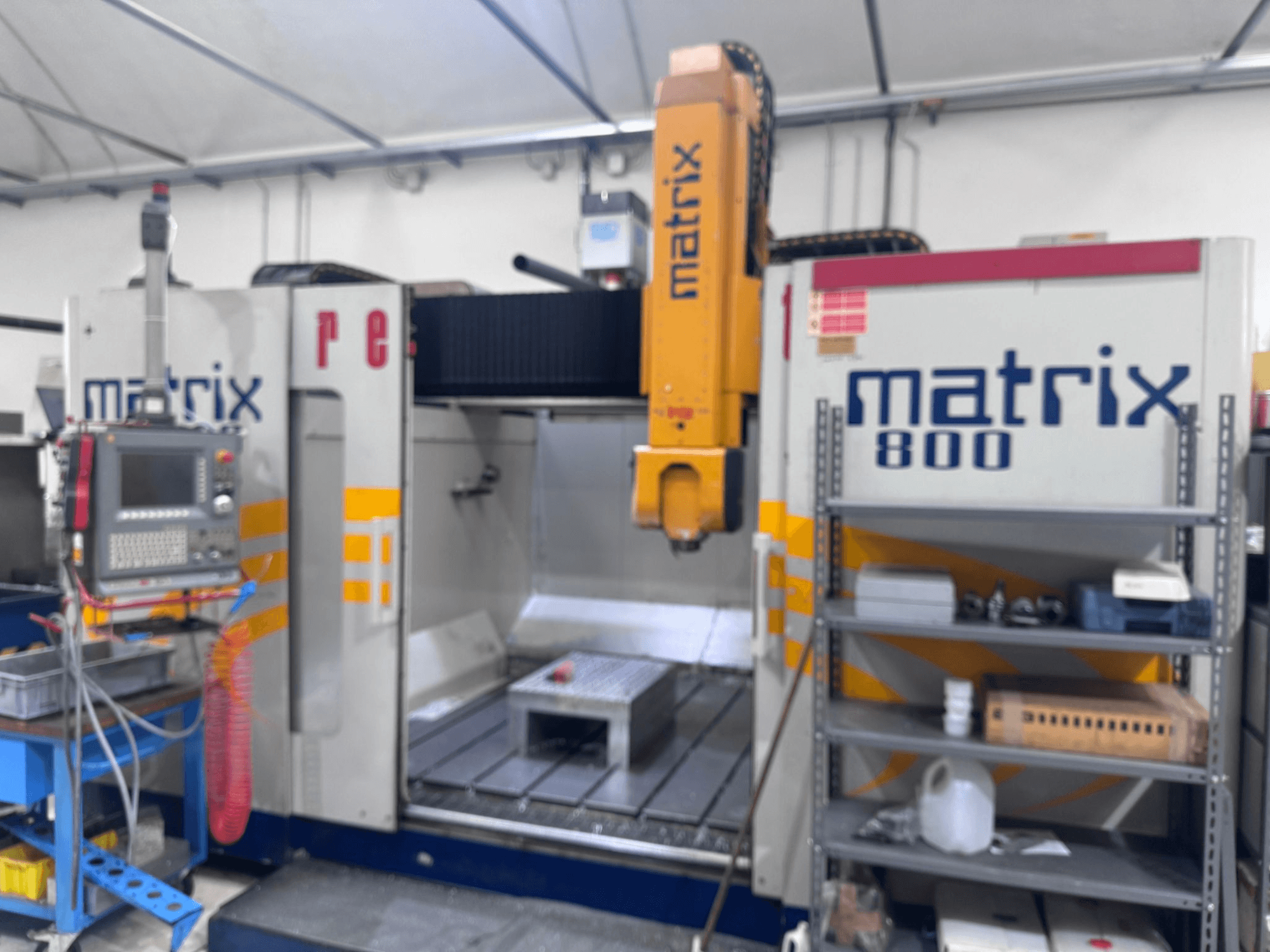 Верстат з ЧПК Matrix 800 в робочому приміщенні, з панеллю керування, інструментами та робочим столом з різними об'єктами.