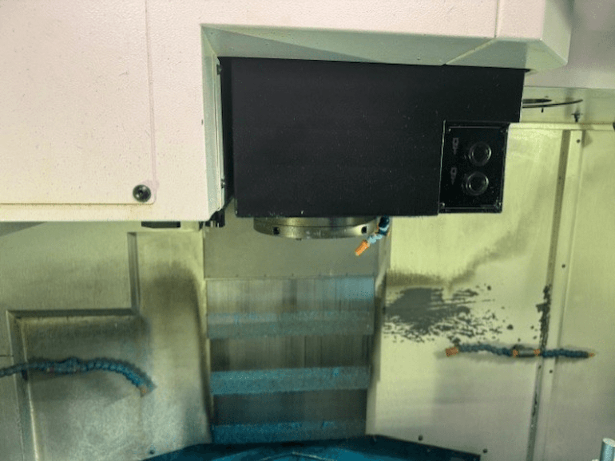 Панель керування фрезерним верстатом з ЧПК та тримач інструменту крупним планом, на якій зображені фірмові деталі, кнопки та робоча поверхня.