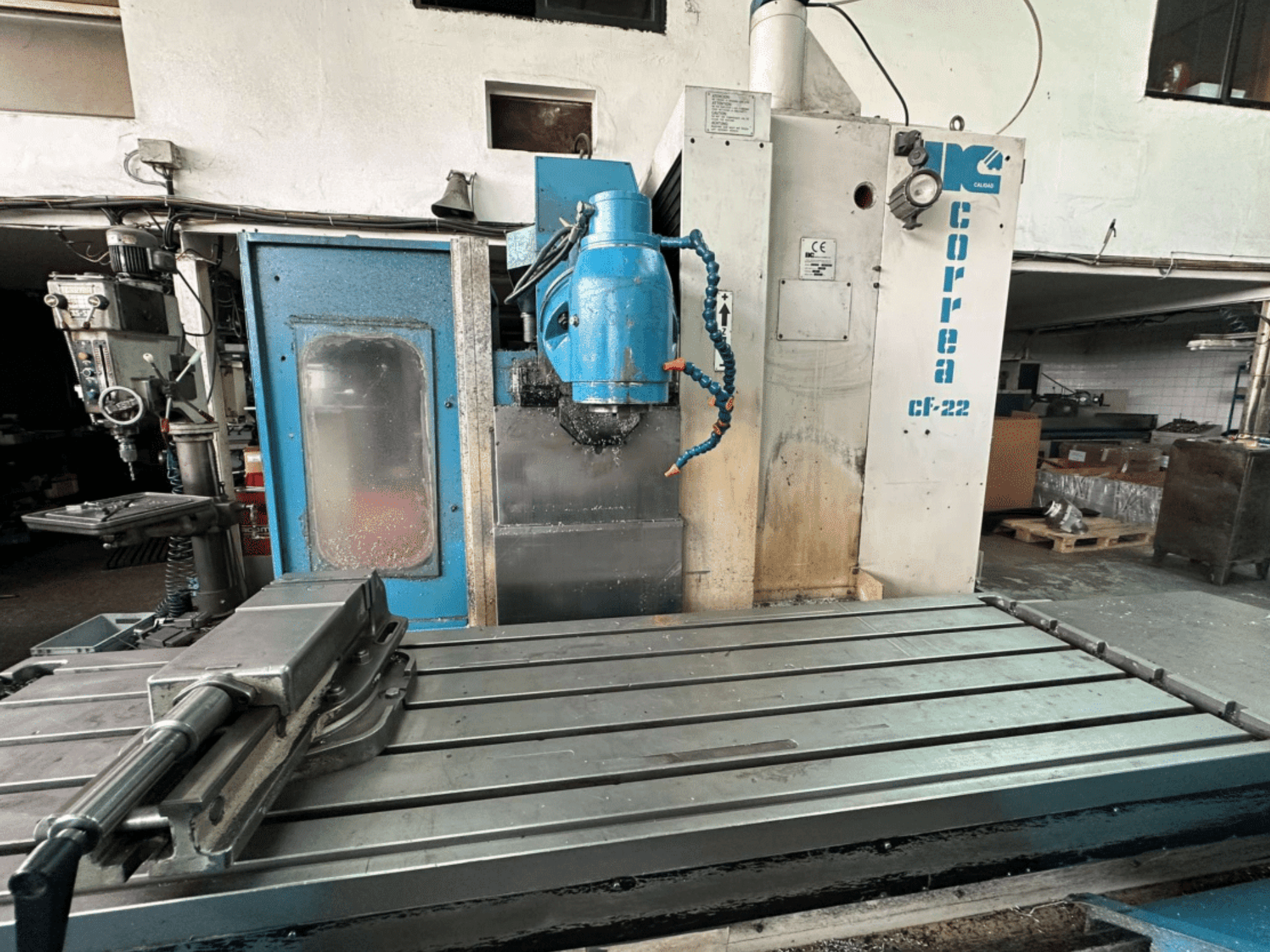 Фрезерний верстат Correa CF-22 показаний спереду в синьо-сріблястому виконанні, з висувним столом і ріжучою головкою.