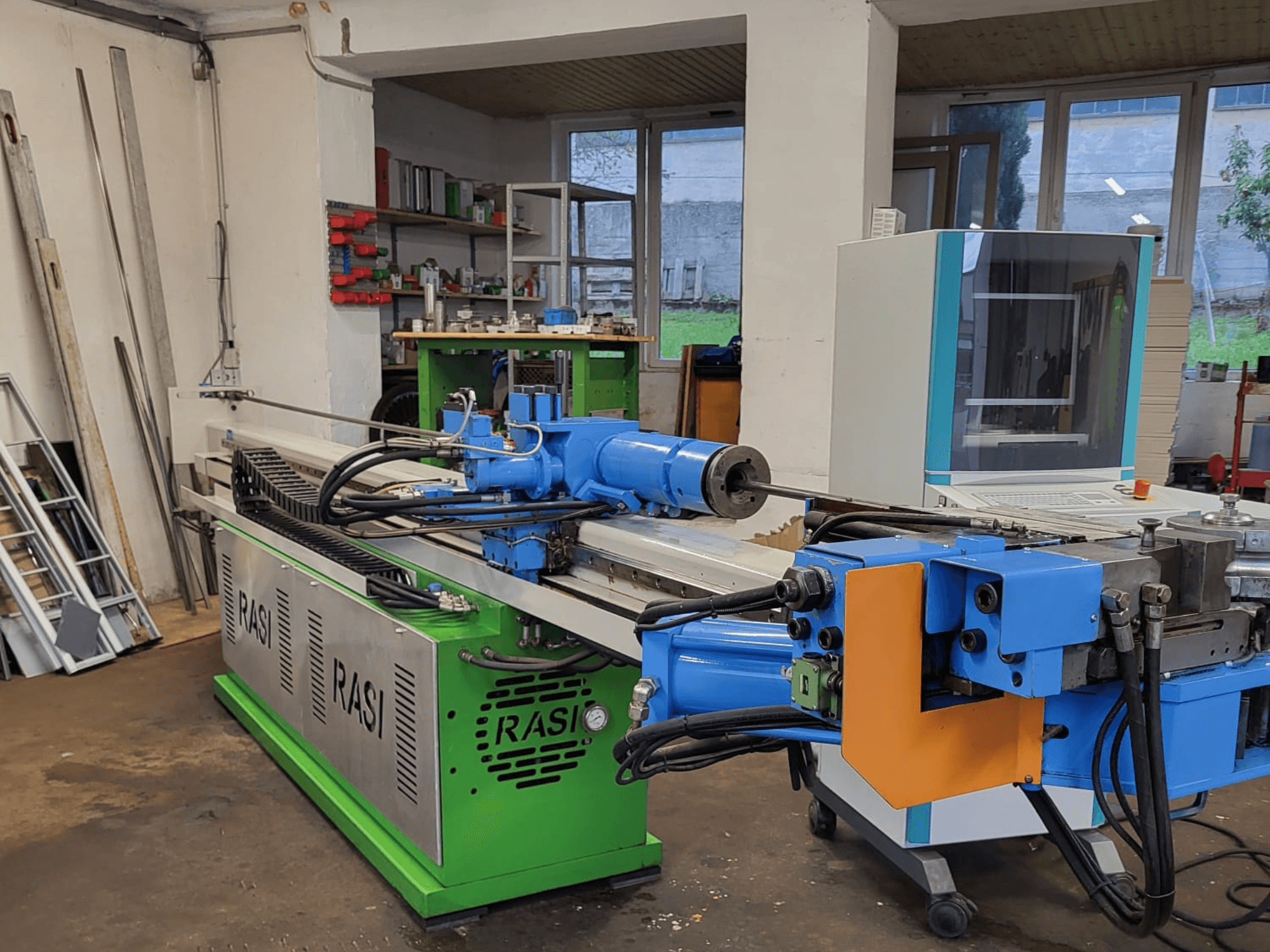Верстат Rasi S 80.6 L G-V3C50 в умовах майстерні, вид збоку з синіми та зеленими компонентами та панеллю керування.