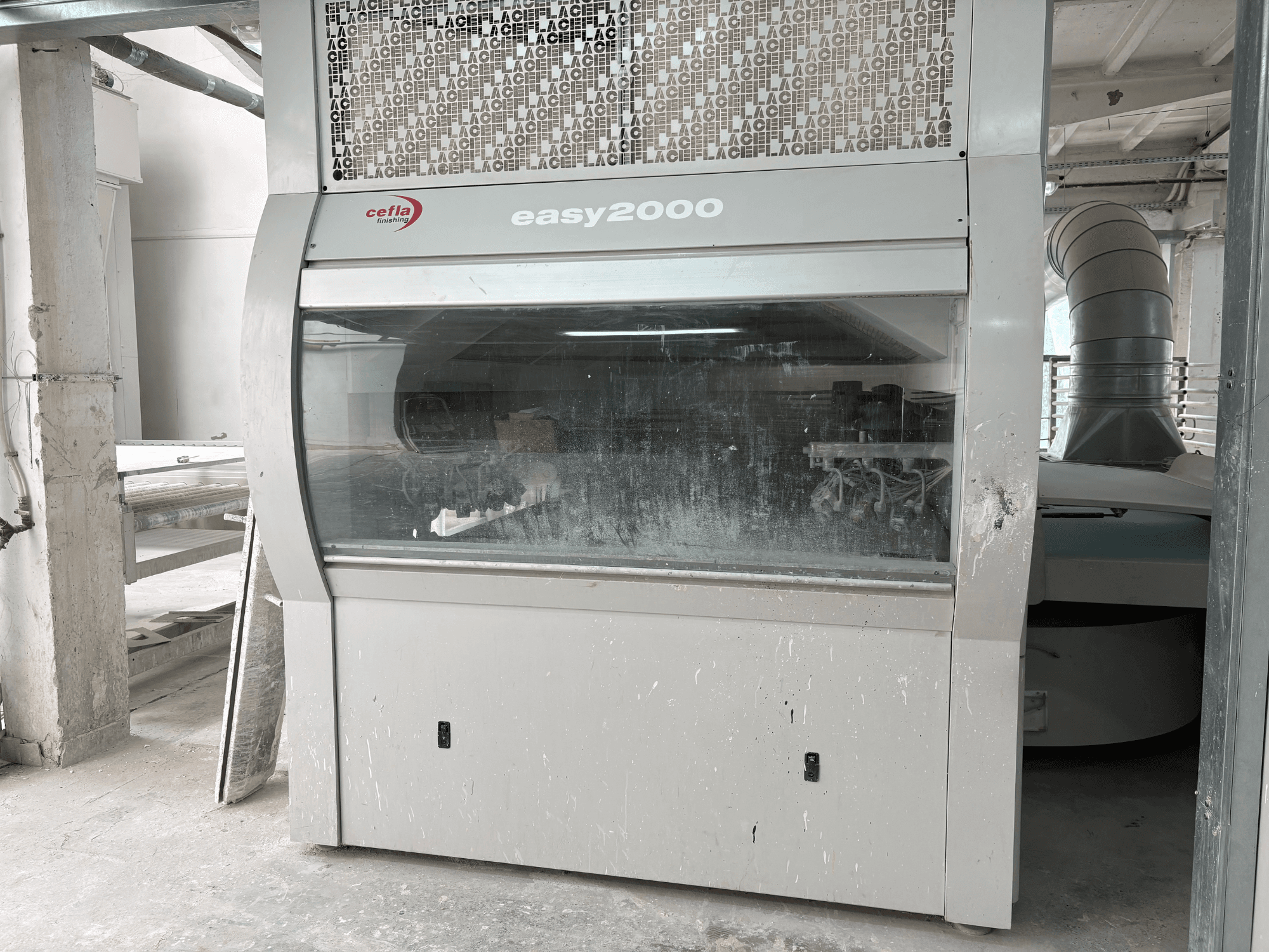 Машина Cefla EASY 2000 D у фронтальному ракурсі: з великою прозорою панеллю, запиленою поверхнею та видимими внутрішніми компонентами.