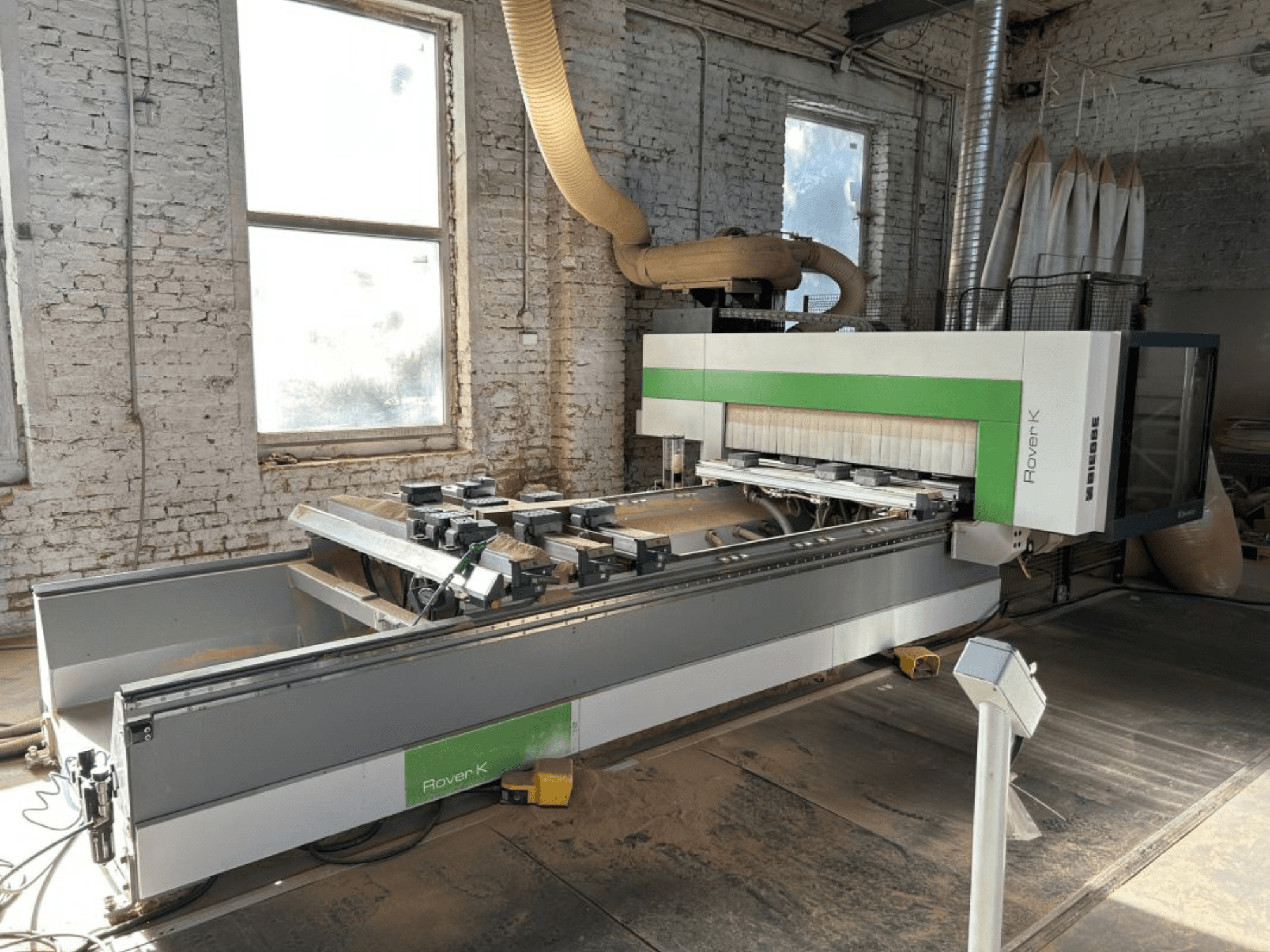 Центр обробки з ЧПУ BIESSE Rover K 1532 G у цеху, вид спереду, на якому видно ріжучі інструменти та робочу поверхню.