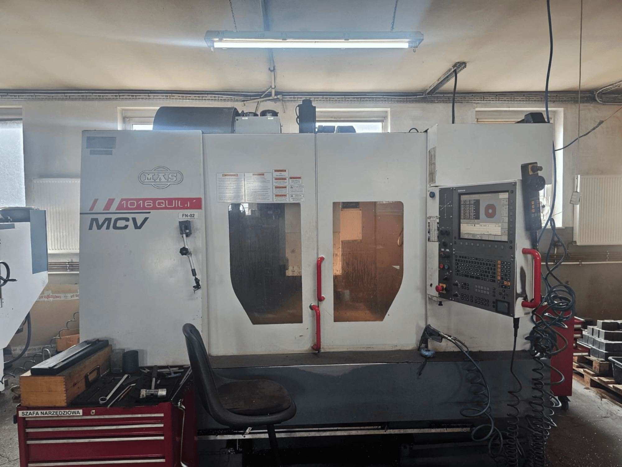 Верстат з ЧПК MVS MCV 1016 QUILL, вид спереду, з панеллю керування, ящиком для інструментів та робочою зоною з інструментами.