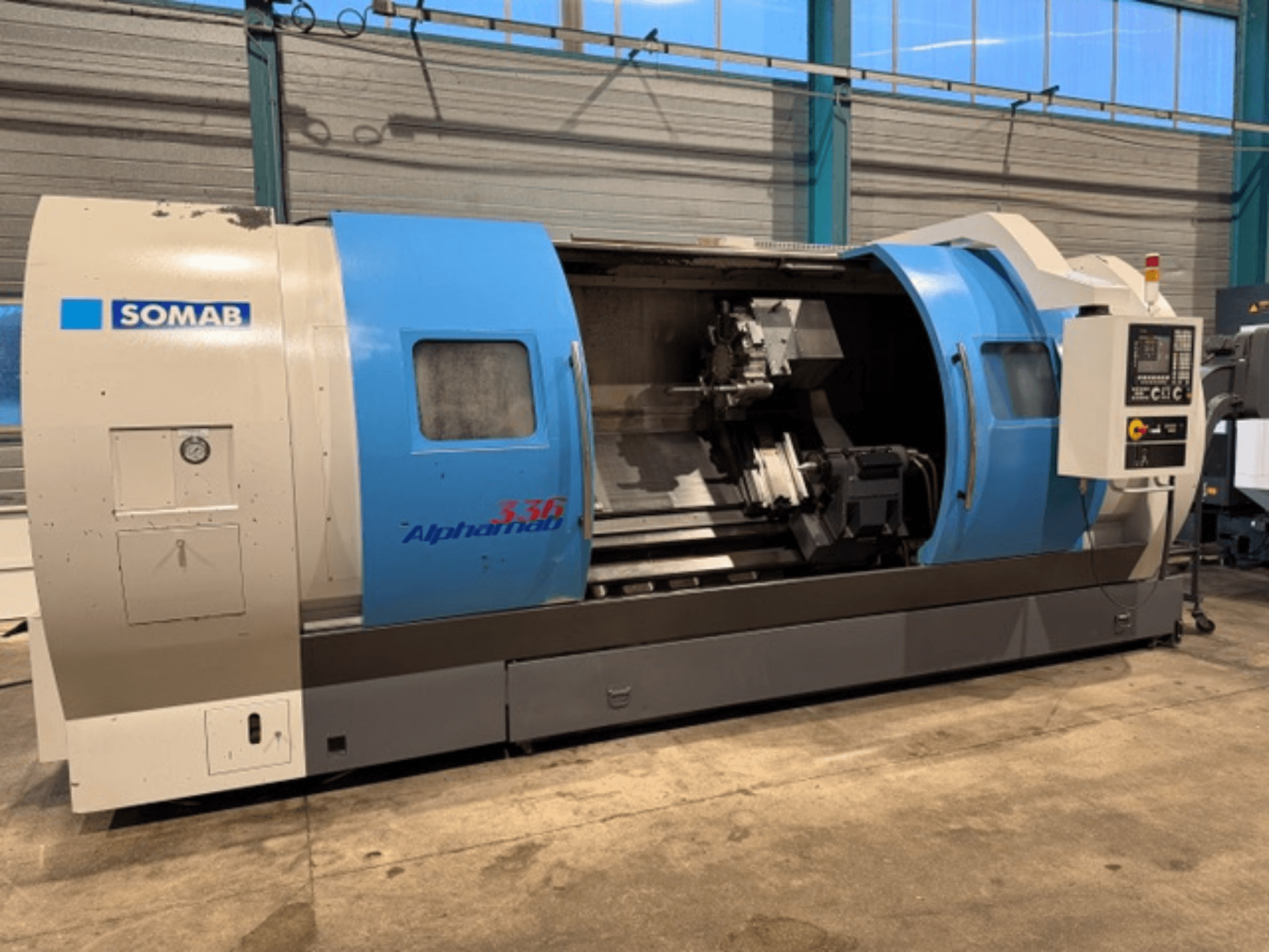 Токарний верстат з ЧПК SOMAB Alpha 336, вид спереду, з синьо-сірим корпусом і панеллю керування збоку.