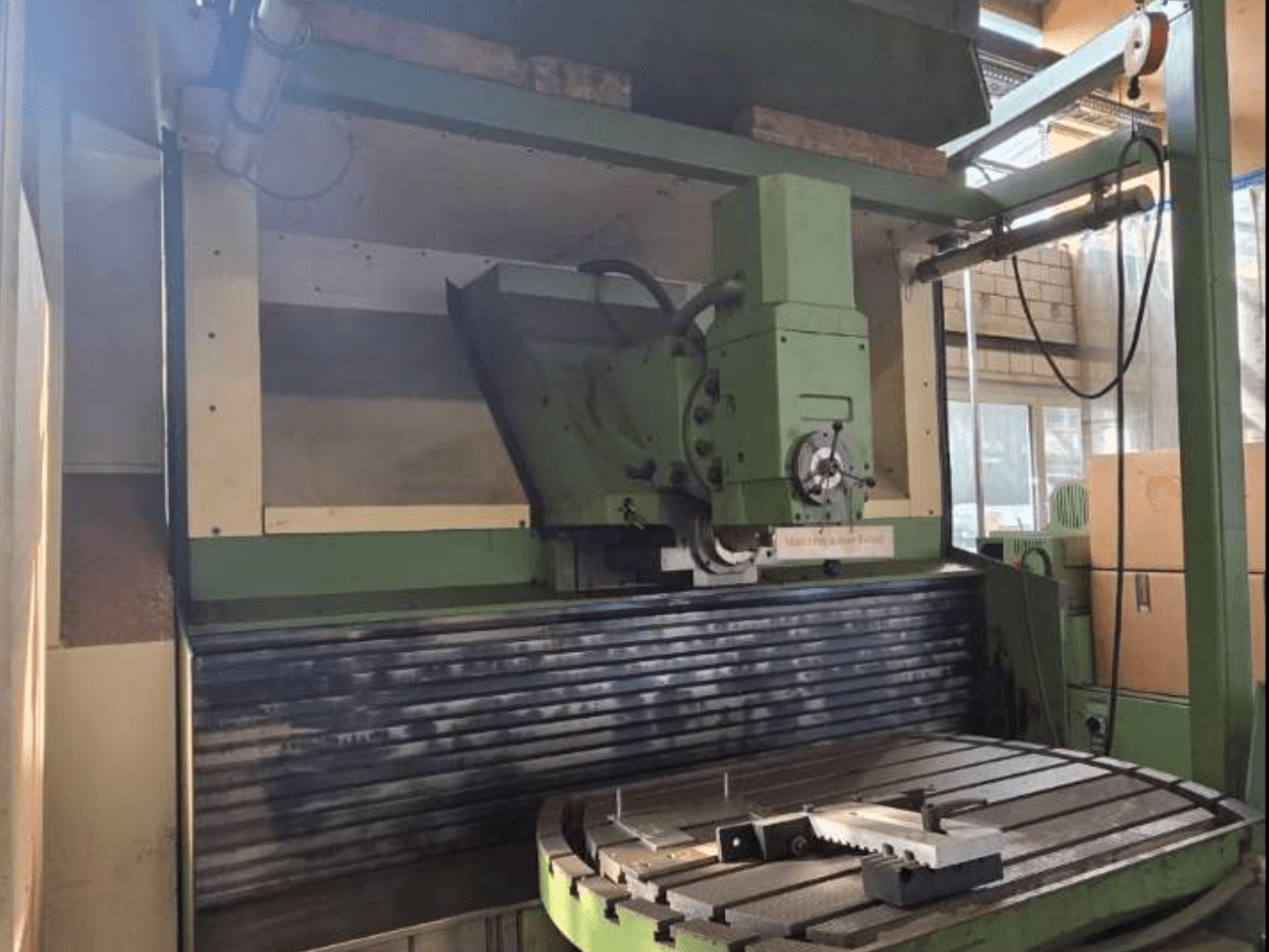 Універсальний обробний центр MAHO MH1000 C спереду, з зеленою конструкцією, шпинделем і поворотним столом із заготовкою.