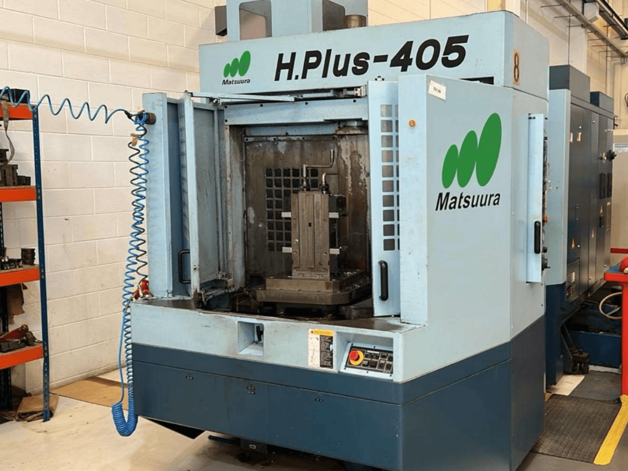 Вигляд спереду горизонтального обробного центру Matsuura H.Plus 405 з відкритими дверцятами, на якому видно робочу зону та панель керування.