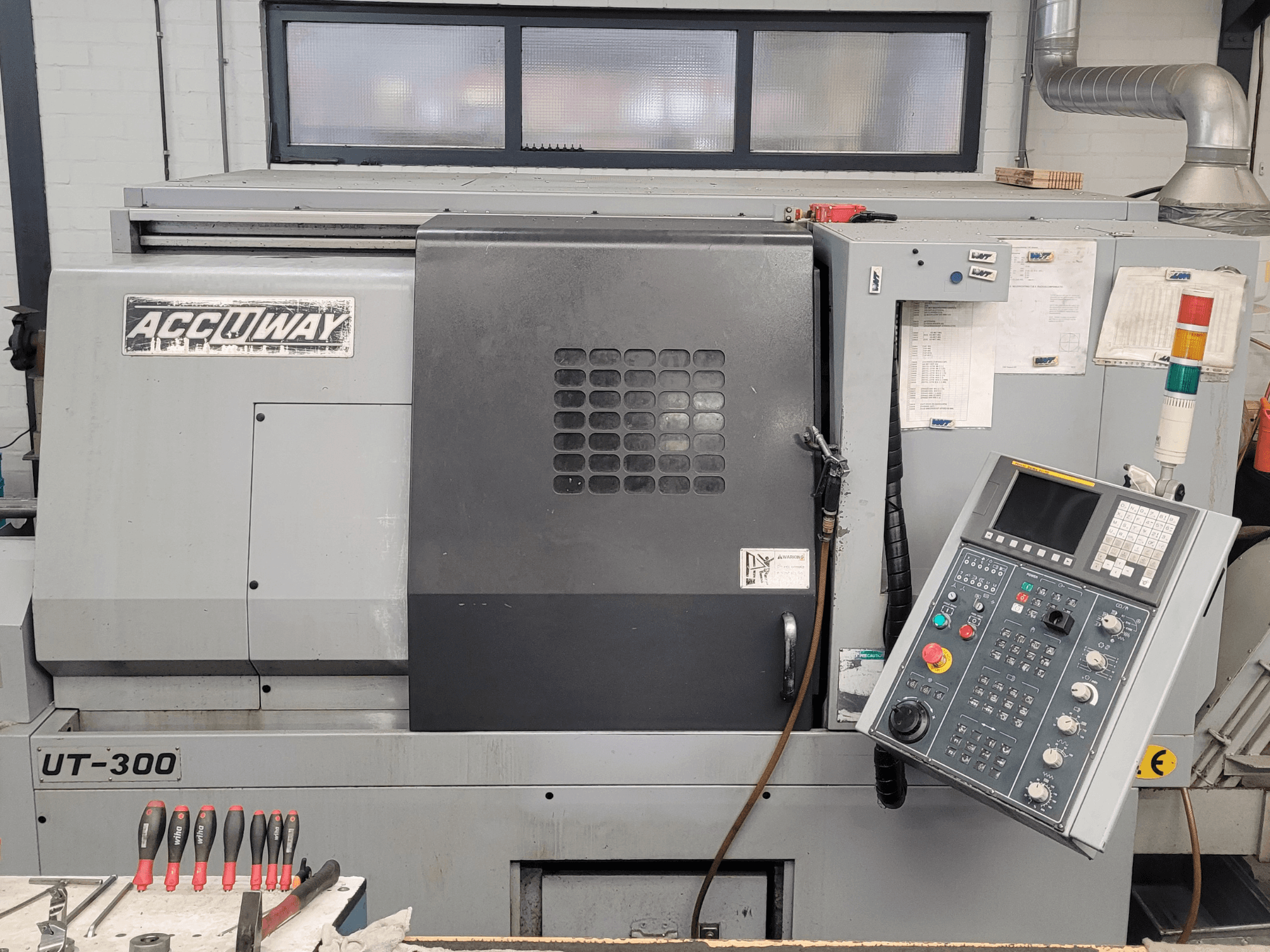 Верстат з ЧПК Accuway UT-300 спереду, з панеллю керування та різними операційними кнопками, в умовах майстерні.
