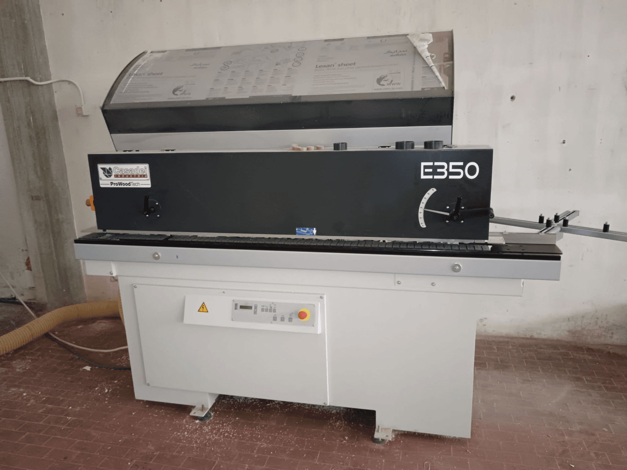 Cesaroli ProWoodtech E350, вид збоку деревообробного верстата з панеллю керування та пилозбірником, встановлений на білій основі.