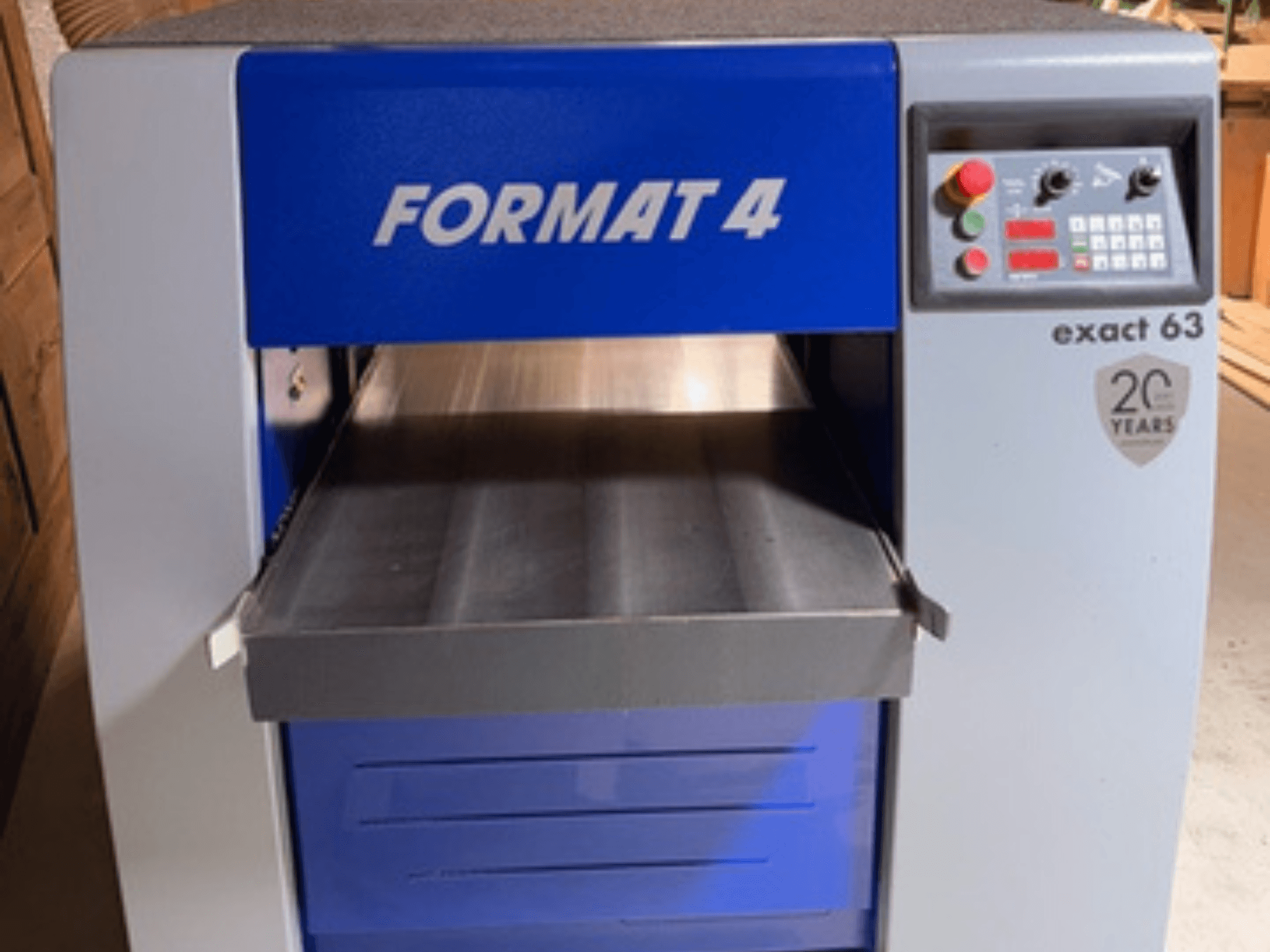 FORMAT 4 Exact 63, вид спереду, з металевим столом подачі та панеллю керування з кнопками та індикаторами.