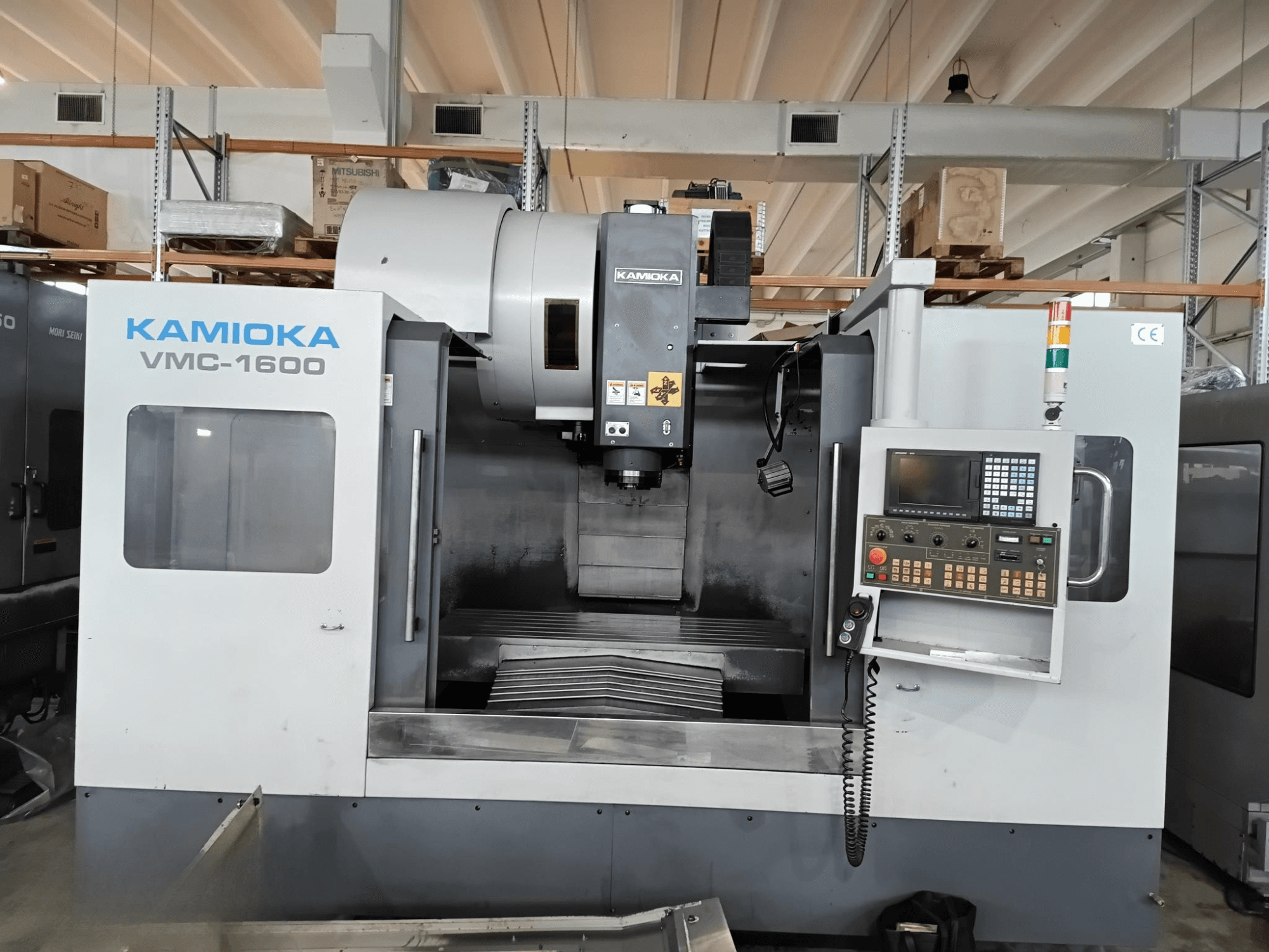 Вертикальний обробний центр Kamioka VMC-1600 у заводських умовах, вид спереду з панеллю керування та видимою робочою поверхнею.