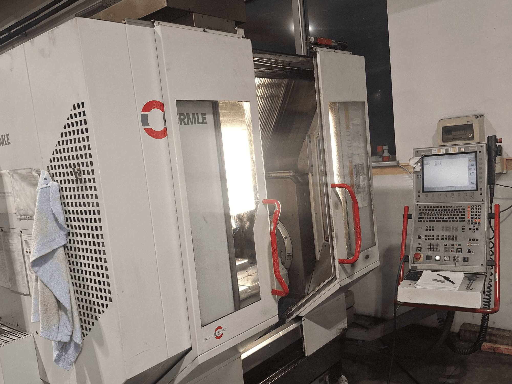 Верстат з ЧПУ марки Cormile, вид спереду з частково відкритими дверима і панеллю керування з екраном і кнопками.