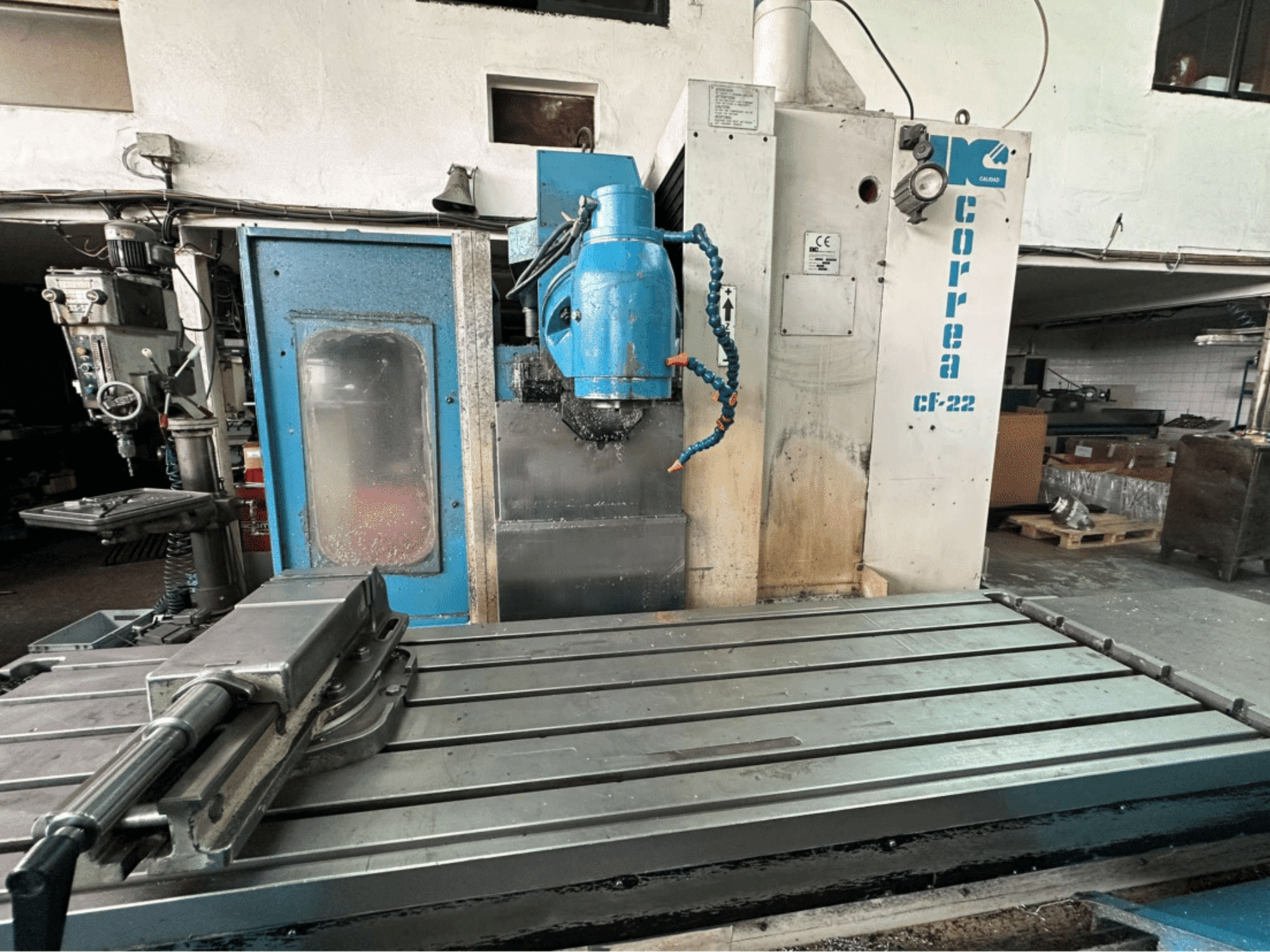 Фрезерний верстат Correa CF-22, вид спереду; має металевий робочий стіл і синьо-білу панель управління з ручками.