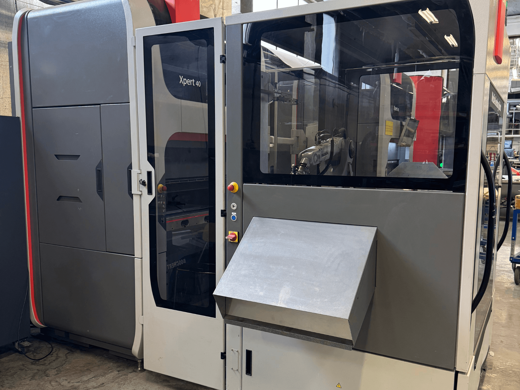 Вид спереду на прес-машину Bystronic Xpert 40/1030, демонструючи панель керування, скляний корпус і чіткі конструктивні особливості.