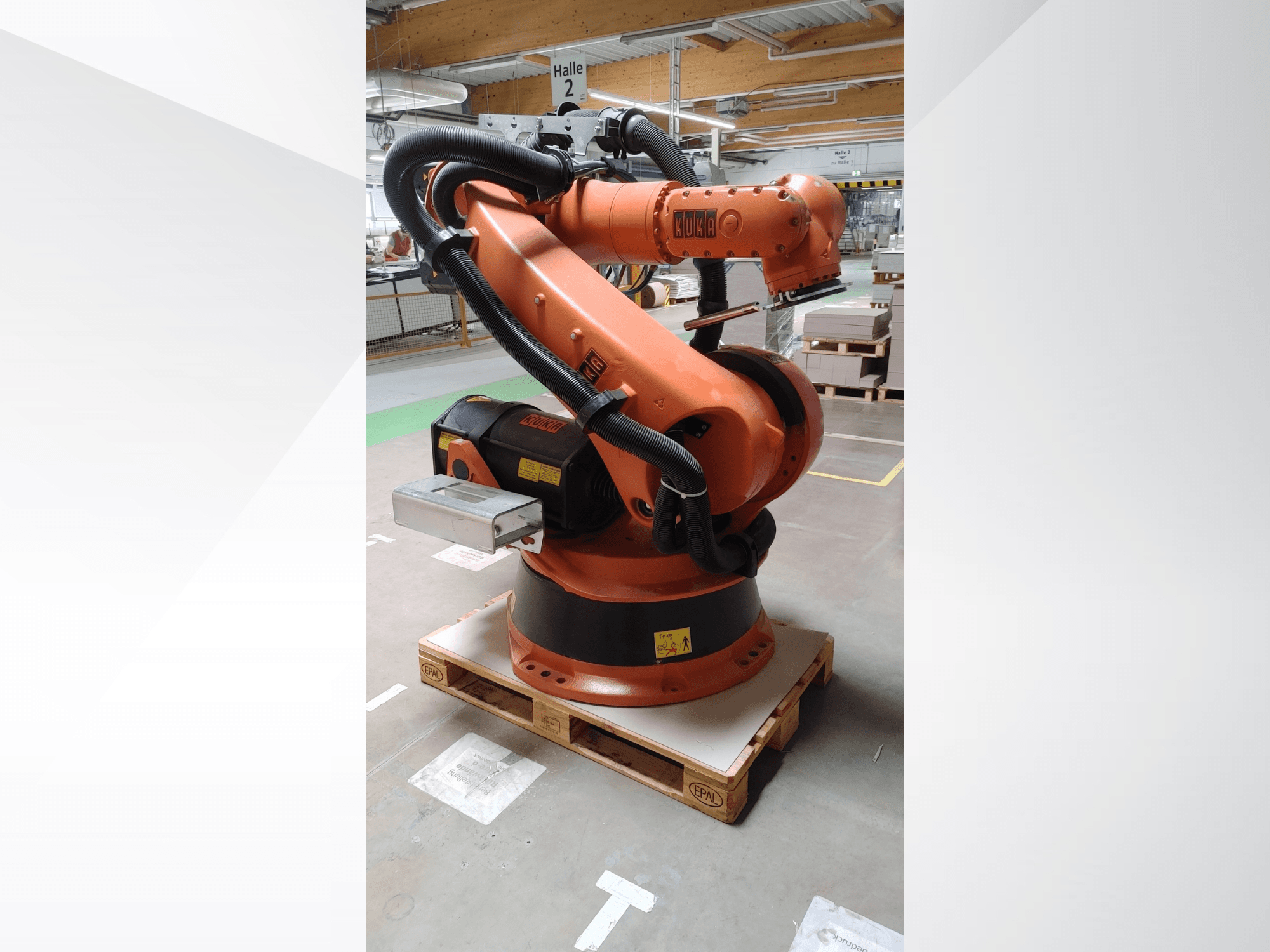 Робот-маніпулятор KUKA KR140-3 COMP помаранчевого кольору, вигляд спереду на дерев'яному піддоні, з вигнутим маніпулятором і блоком управління.