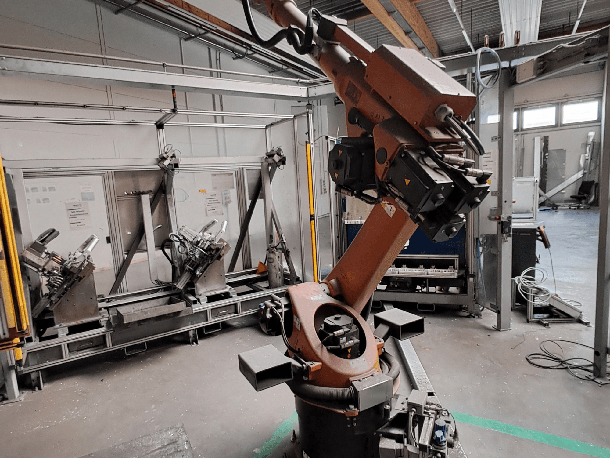 Роботизована рука KUKA KR 30L16-2 у промисловому середовищі, вид збоку, на якому видно суглоби руки та захватні пристосування.
