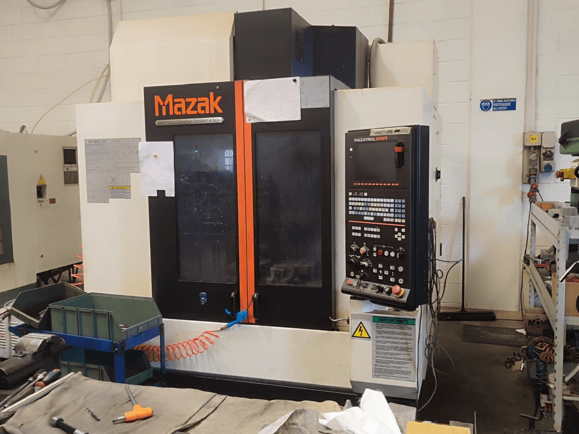 Вертикальний обробний центр Mazak VCS 430A, вид спереду, що демонструє панель керування та робочі деталі в умовах майстерні.