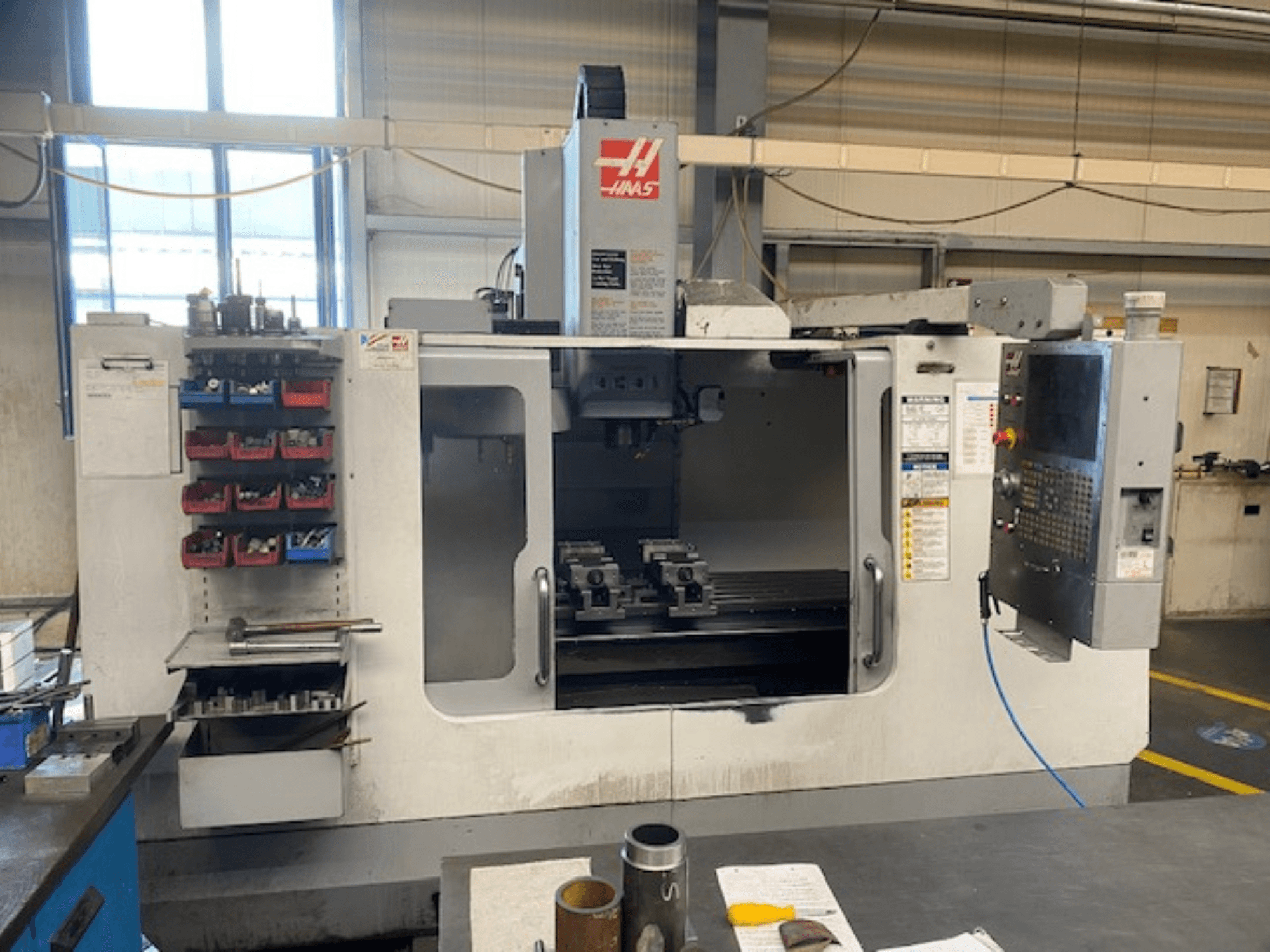 Фрезерний верстат з ЧПК Haas, модель VF-2, вид спереду: видно сховище для інструментів, панель керування та інструменти робочого простору.