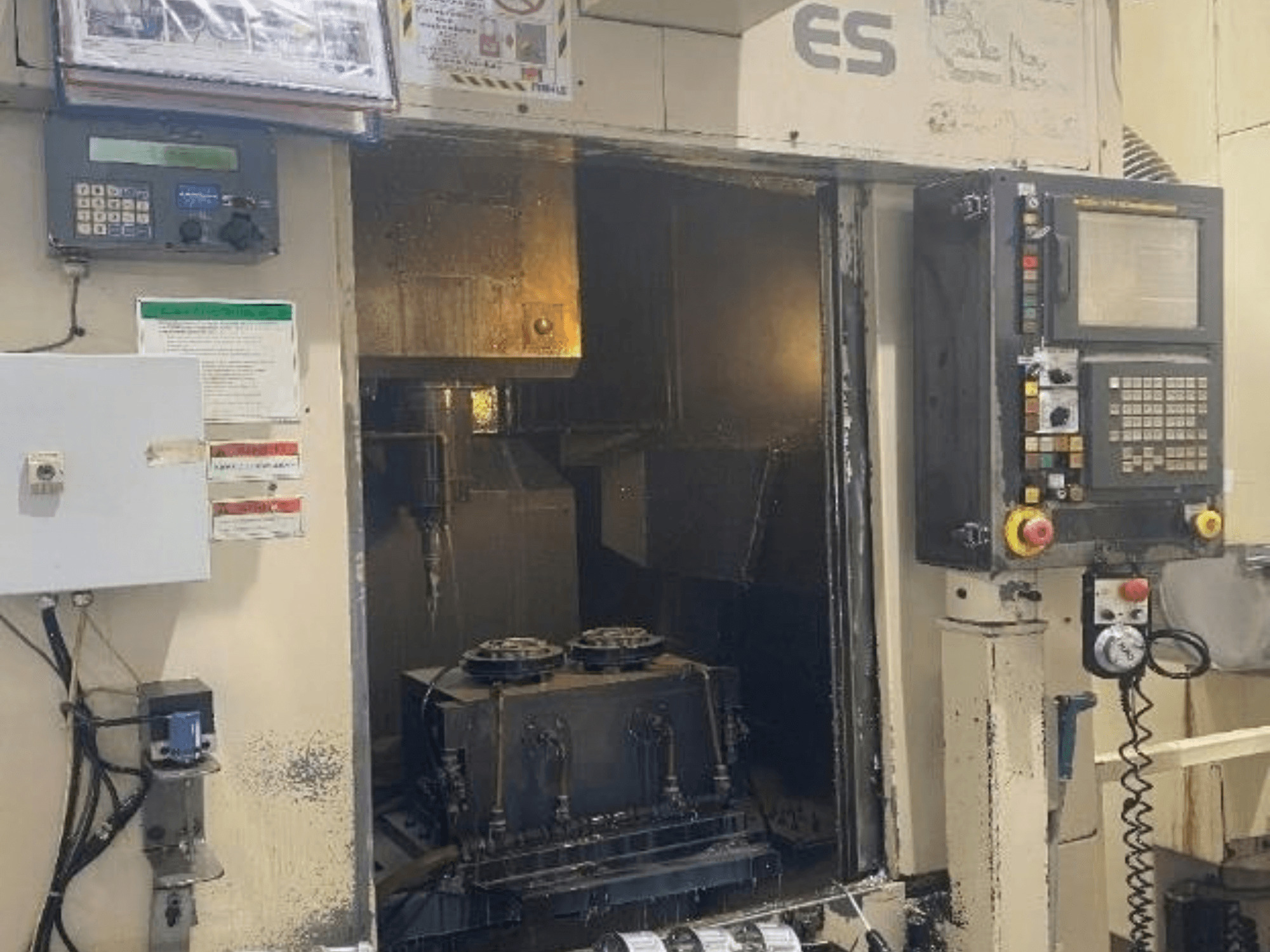 Вигляд спереду вертикального обробного центру Enshu ES450 із панеллю керування, внутрішнім простором та зоною розміщення інструментів.