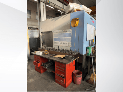 Обробний центр Doosan з червоним робочим столом і сховищем для зберігання інструментів та обладнання, вид спереду.