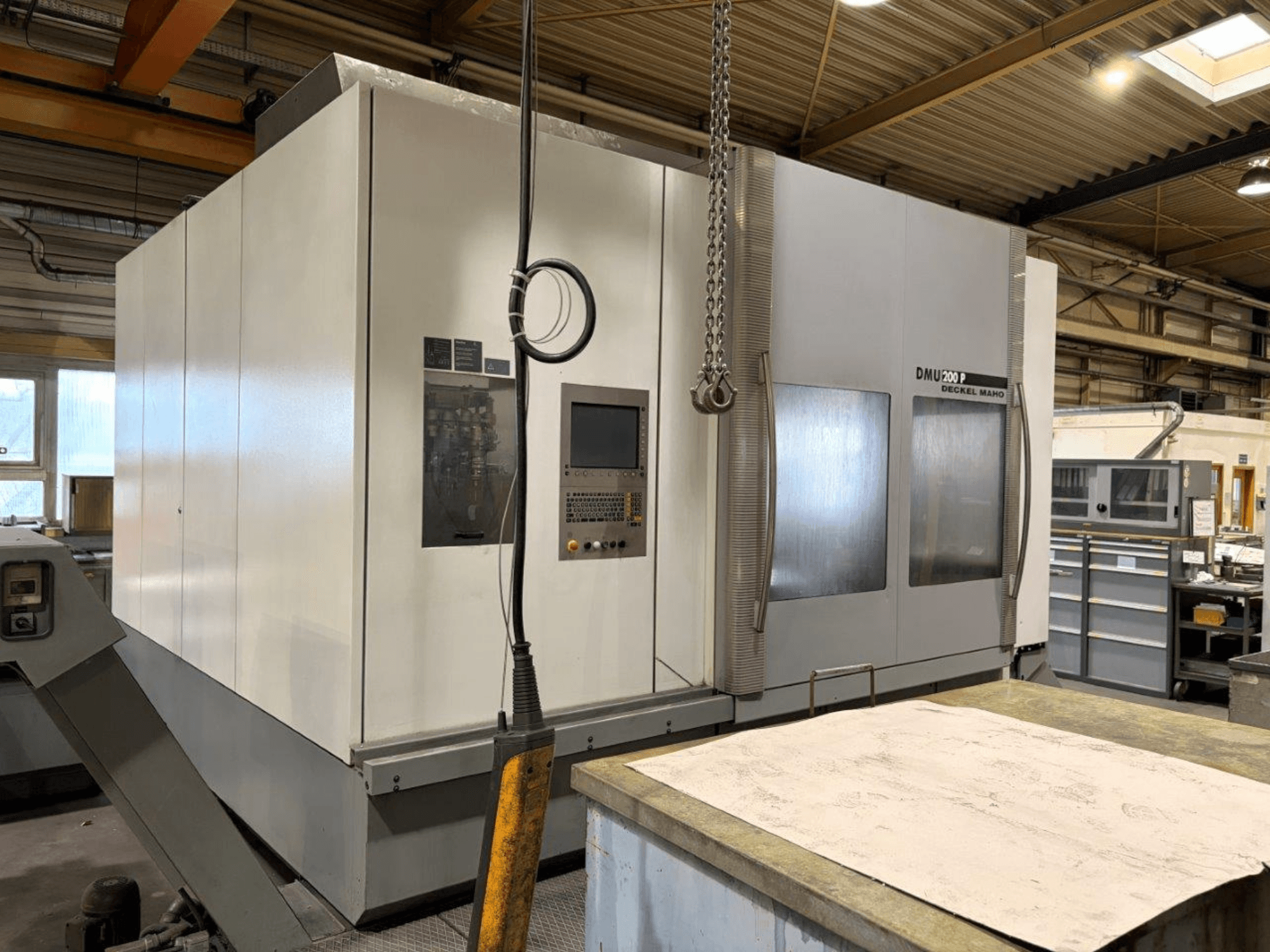 Універсальний обробний центр DMG MORI DMU 200 в майстерні, вид спереду, демонструє панель керування та зовнішні особливості.
