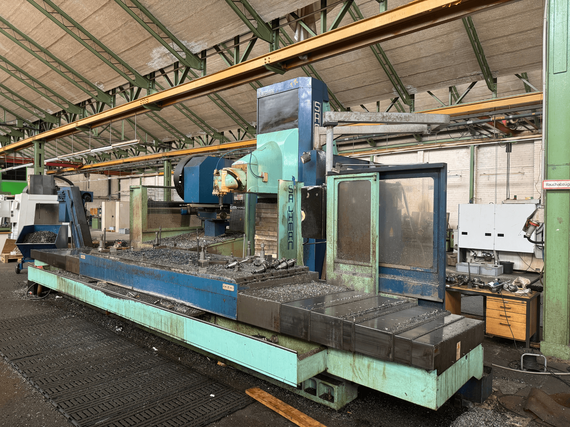 Фрезерний верстат Salvador у заводській комплектації, вид спереду, синьо-зелена кольорова гама, з металевою стружкою на станині.