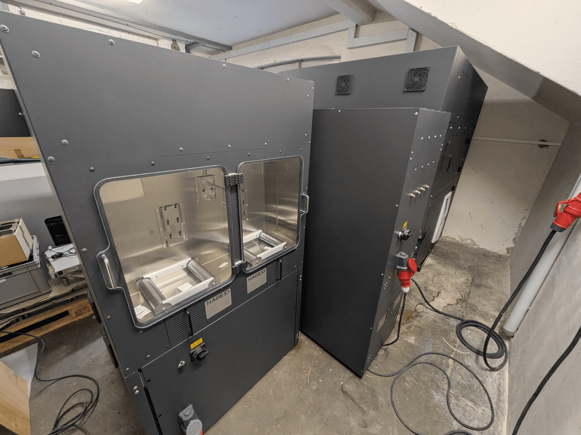 3D-принтер HAGE 3D Mex-One-A з пластиковим корпусом, вид збоку, на якому видно дві прозорі дверцята та панель керування.