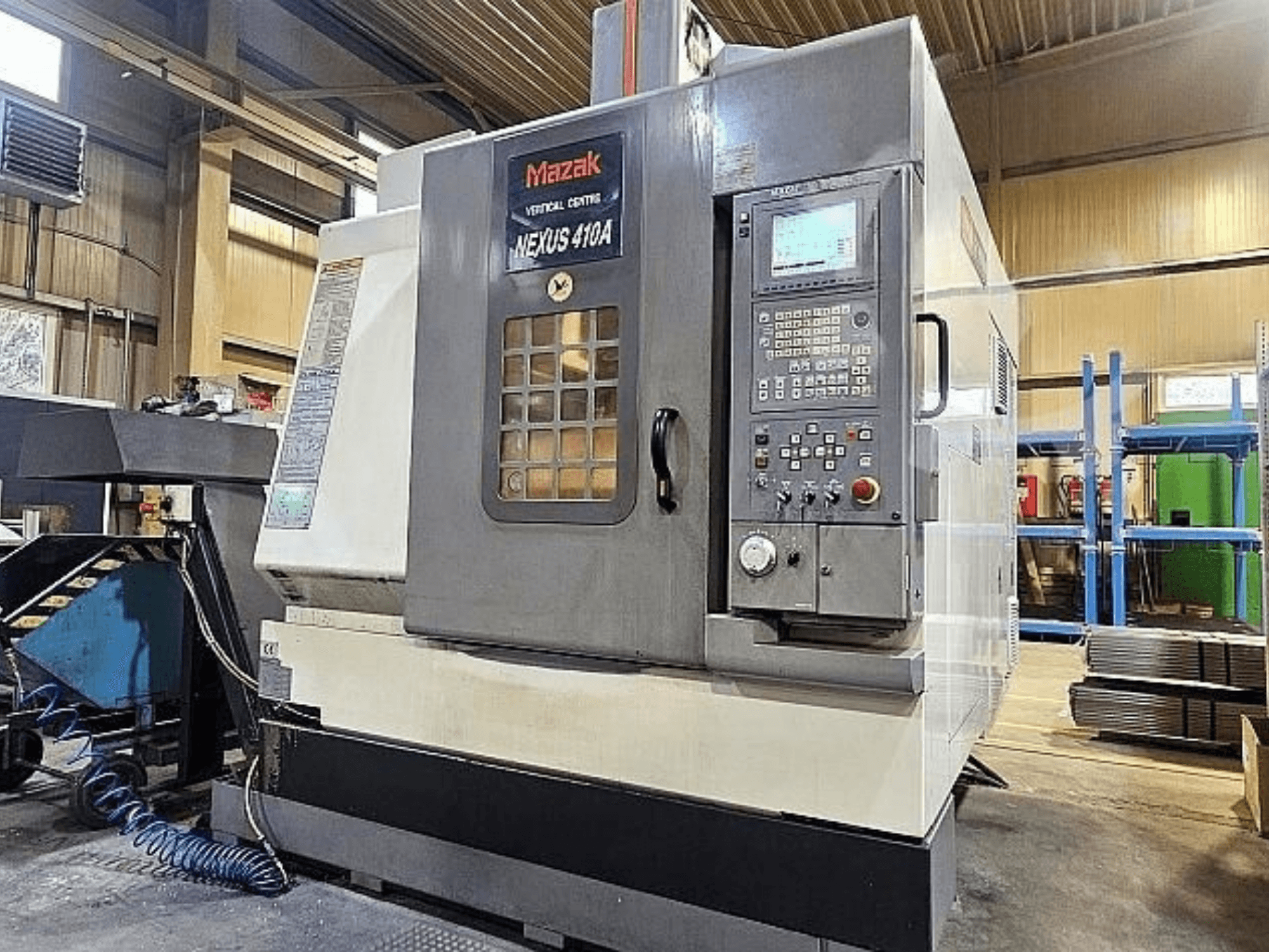 Вертикальний обробний центр Mazak VCN-410A, вид збоку, на якому видно панель керування, тримач інструменту та робочі елементи.