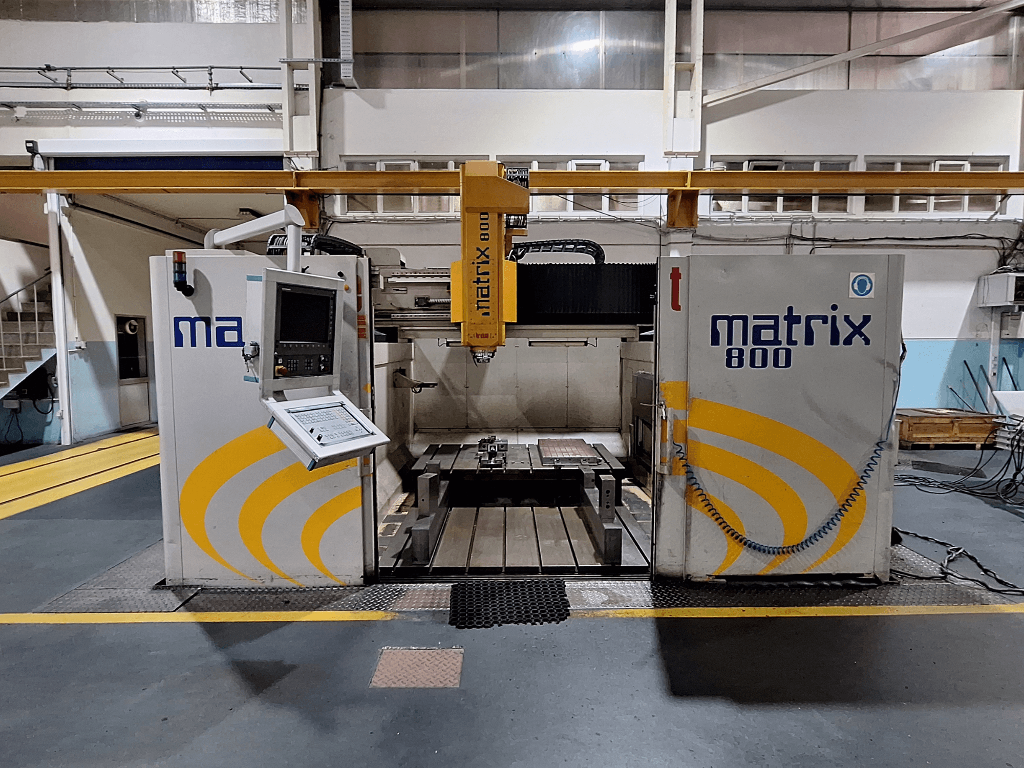 Портальний фрезерний верстат Breton Matrix WM 800 K25 в майстерні, з панеллю керування та робочим столом спереду.