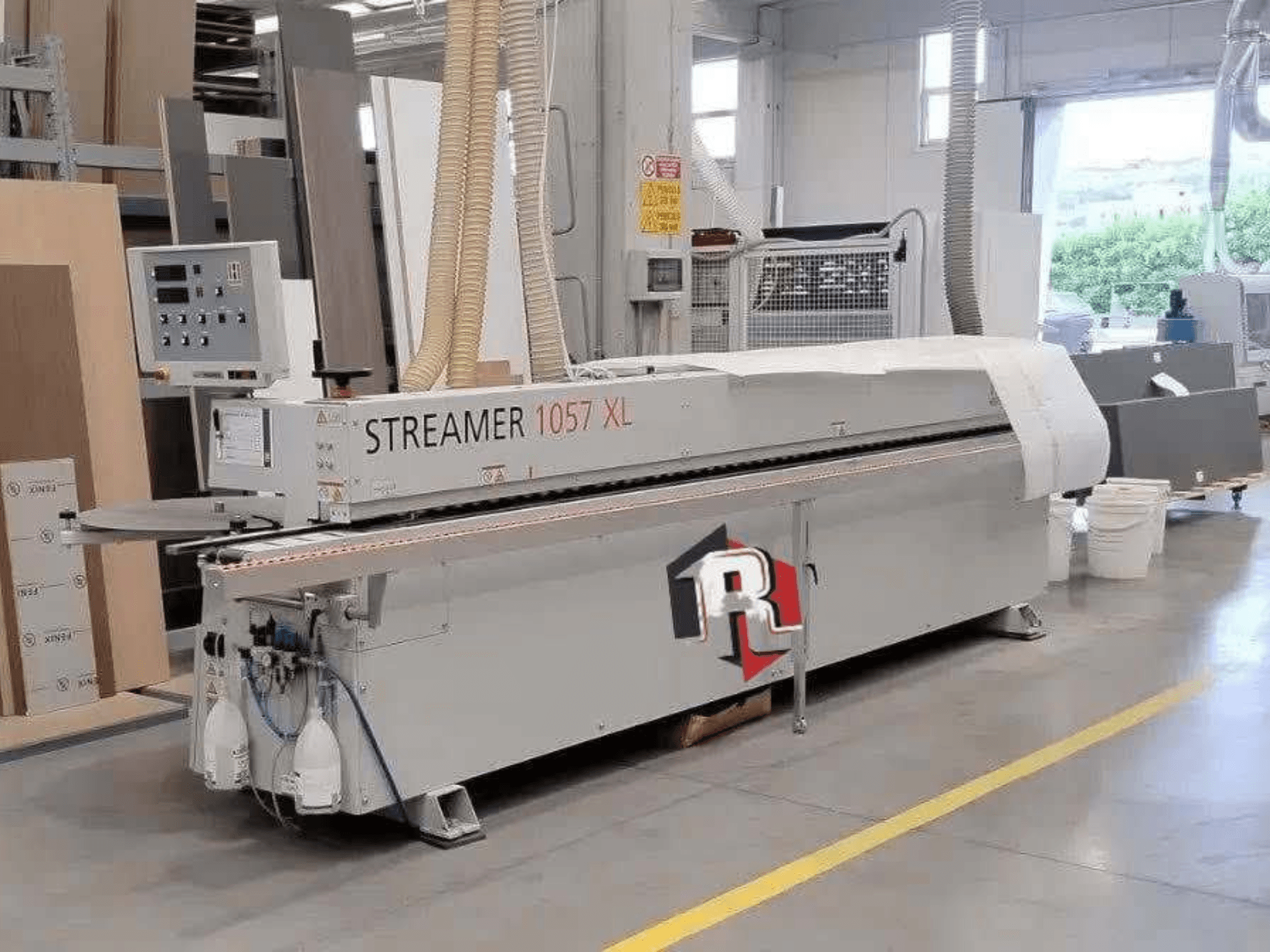 Кромкооблицювальна машина HOLZHER STREAMER 1057 XL у цеху, вид збоку з видимою панеллю керування та повітряними шлангами.