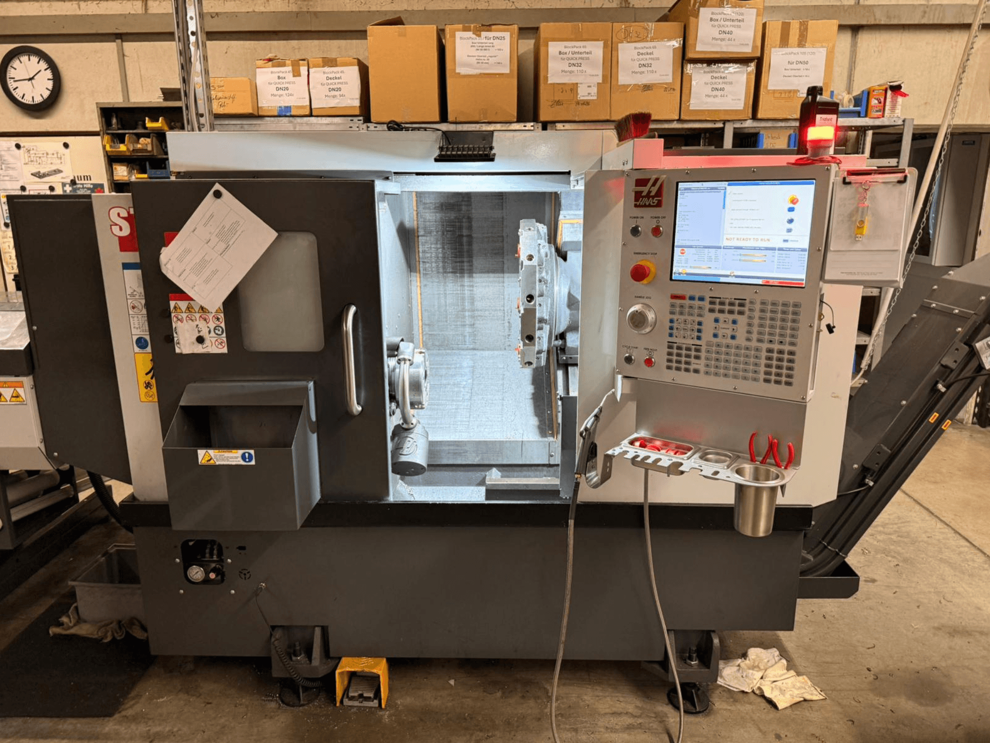Горизонтальний токарний верстат HAAS ST-15 показаний збоку, з цифровою панеллю керування та робочими компонентами.