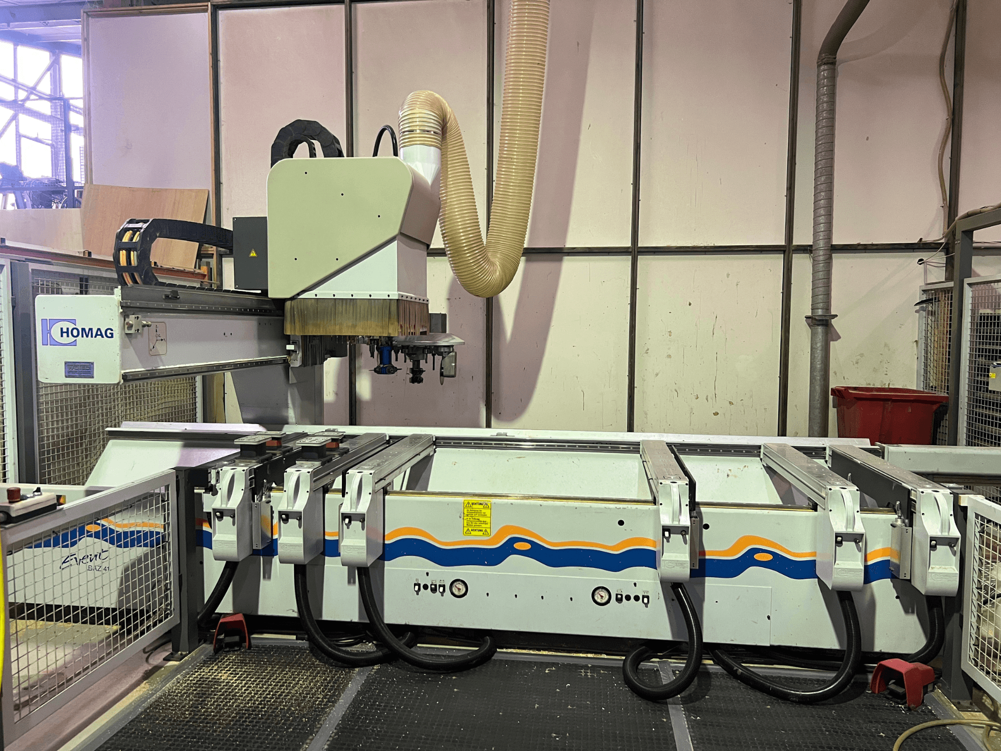 Верстат з ЧПК HOMAG BIZ 4 в майстерні; вид спереду: система відсмоктування пилу та панель керування з кабелями.