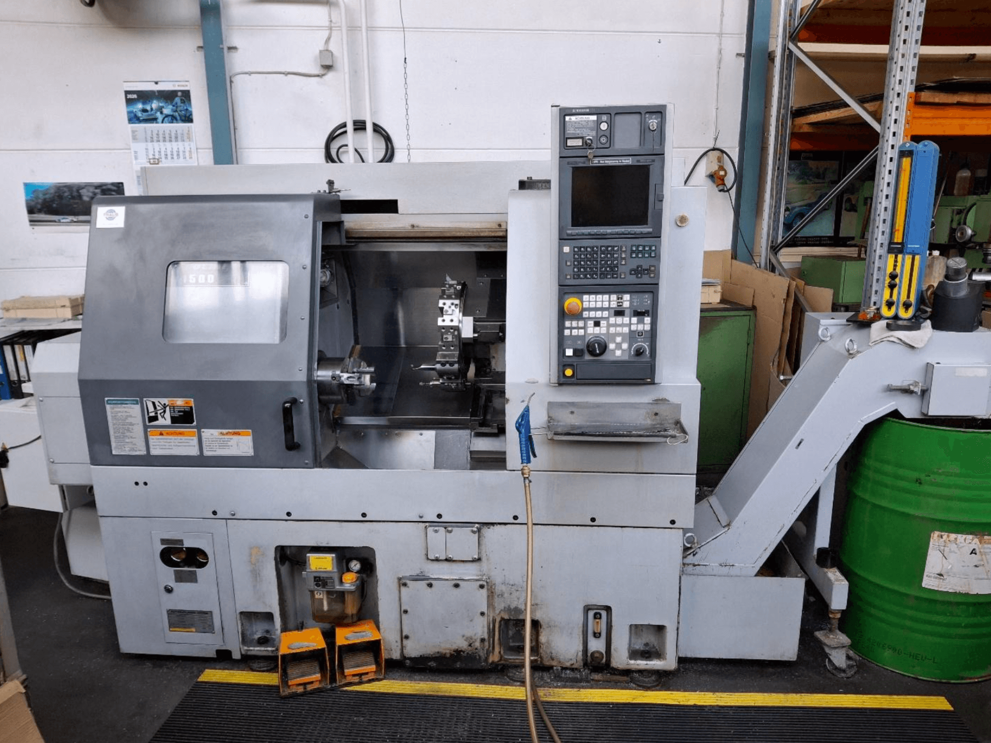 Горизонтальний токарний верстат MORI SEIKI CL 1500 T, вид спереду з панеллю керування, видимими інструментами та робочим дисплеєм.
