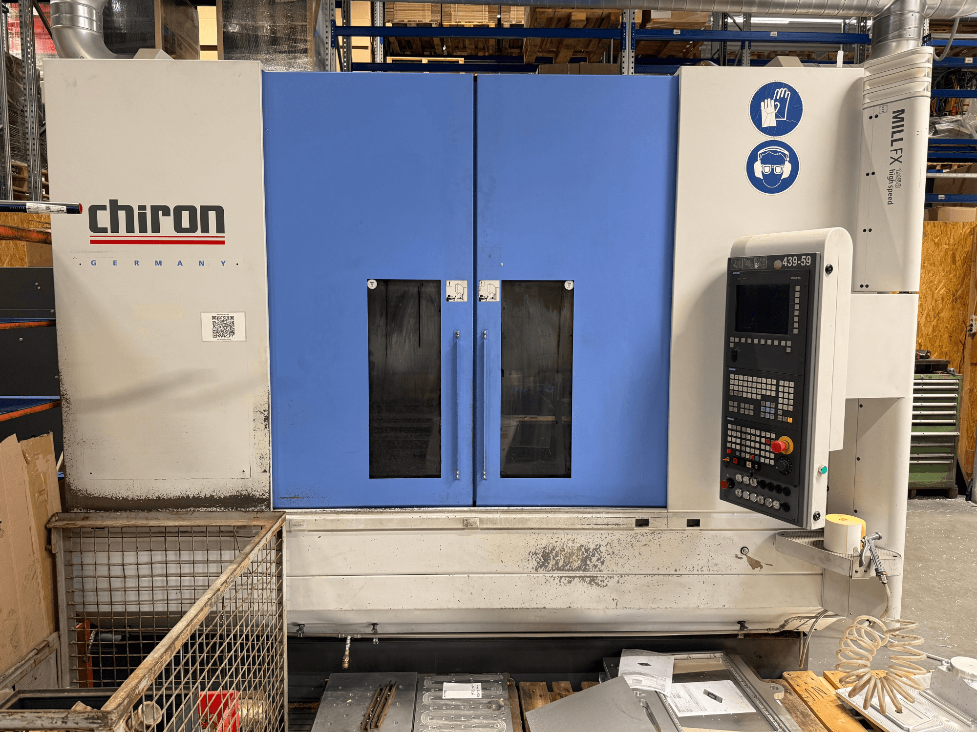 Вертикальний обробний центр CHIRON MILL FX 1250, вид спереду, з панеллю керування та знаками безпеки, готовий до виконання прецизійних робіт.