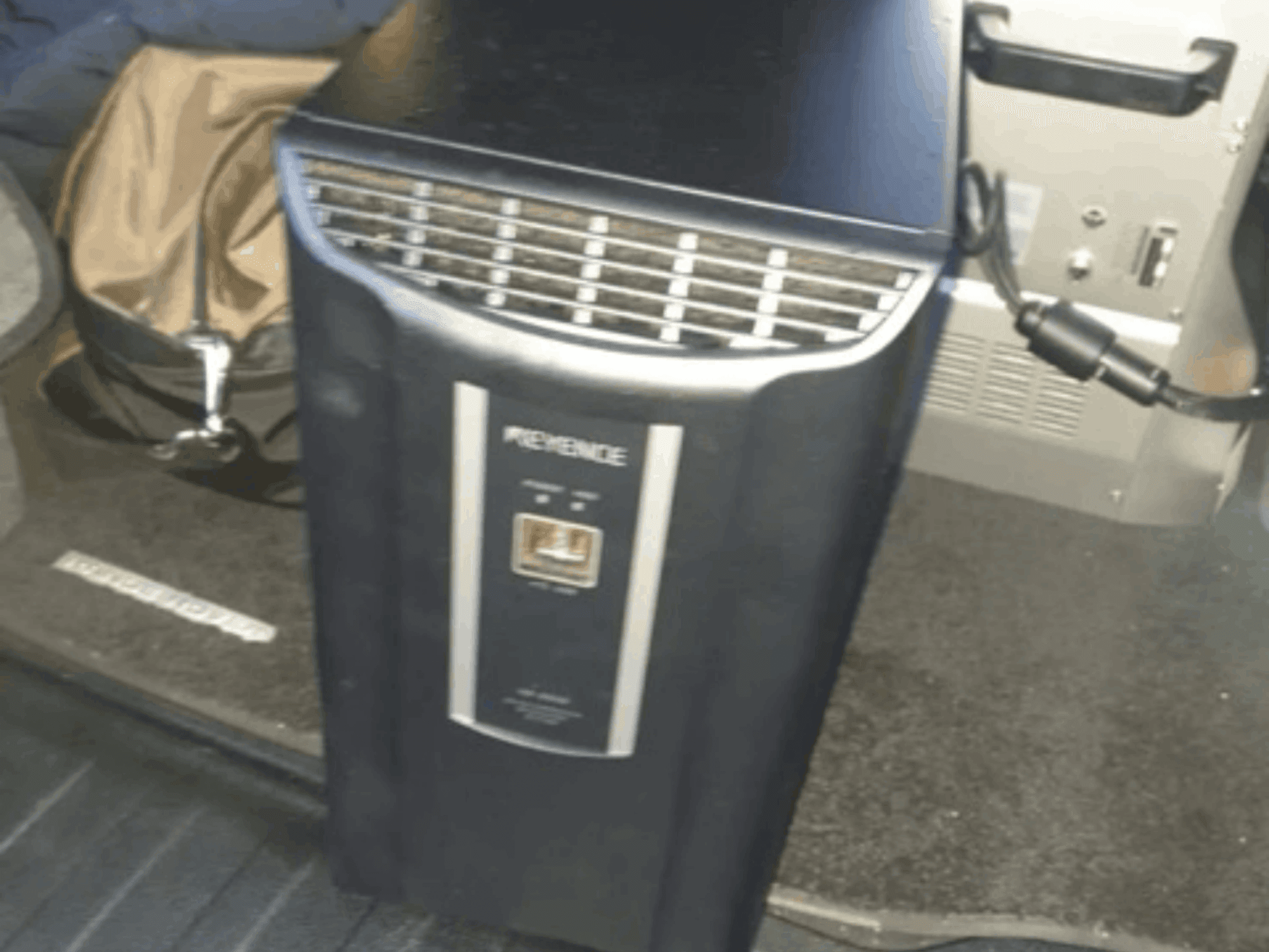 Система автоматизації KEYENCE IM-8030 у вигляді спереду, демонструючи панель управління та вентиляційні отвори на тлі інтер'єру автомобіля.