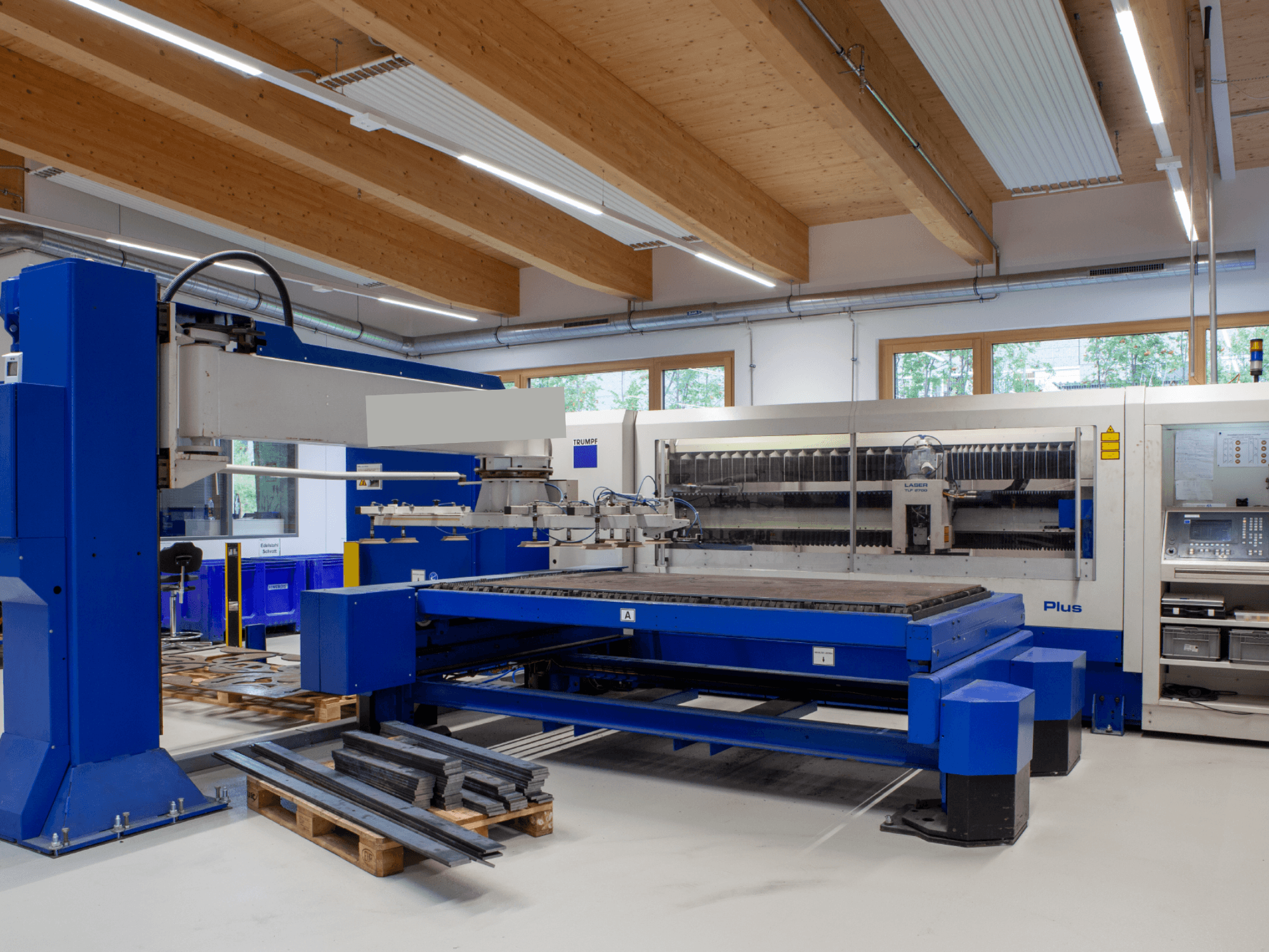 Лазерний верстат для різання CO2 TRUMPF TRUMATIC L 2530 Plus у цеху, що вирізняється великим робочим столом та промисловим дизайном.
