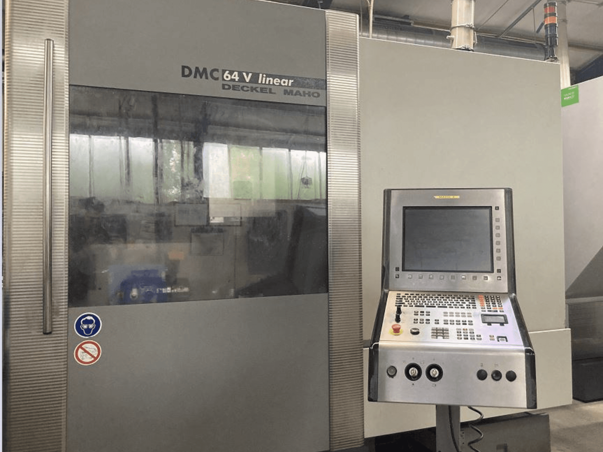 Лінійний вертикальний обробний центр DMG DECKEL MAHO DMC 64V, вид спереду з панеллю керування та дисплеєм.