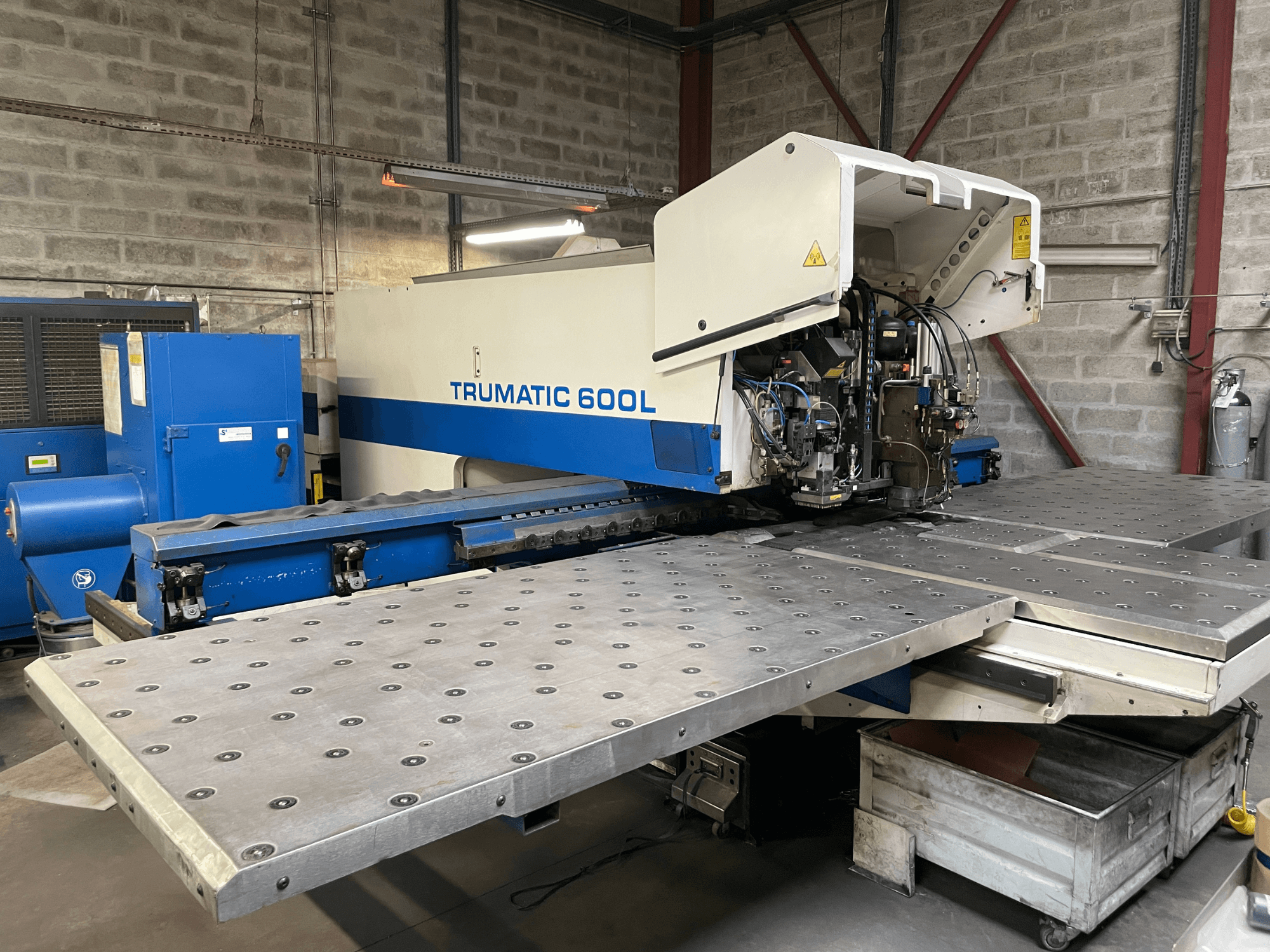 Машина для лазерного різання CO2 TRUMPF TRUMATIC TC 600L, вид спереду, видно стіл для різання металу та панель керування.