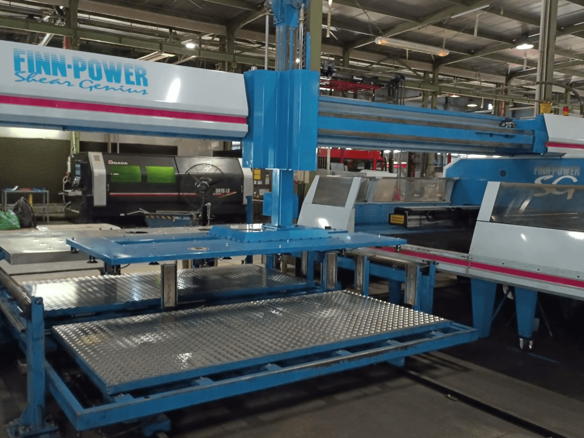 Штампувальний верстат з ЧПУ Finn-Power SG6 «Shear Genius» у фронтальному ракурсі, на якому видно металеві столи та конструктивні особливості.
