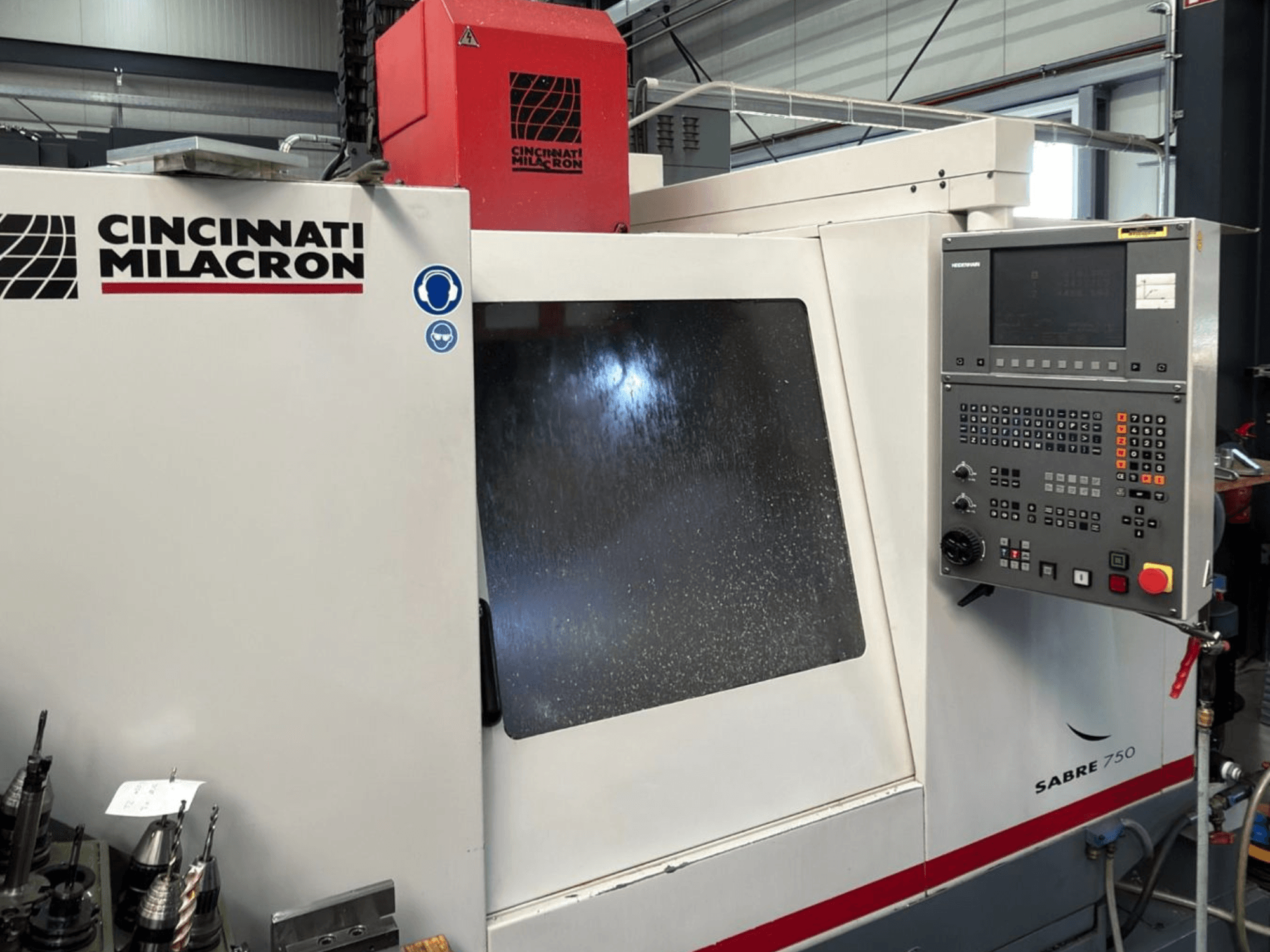 Вертикальний обробний центр Cincinnati Milacron Sabre 750, вид спереду, з панеллю керування та частково затуманеним склом.