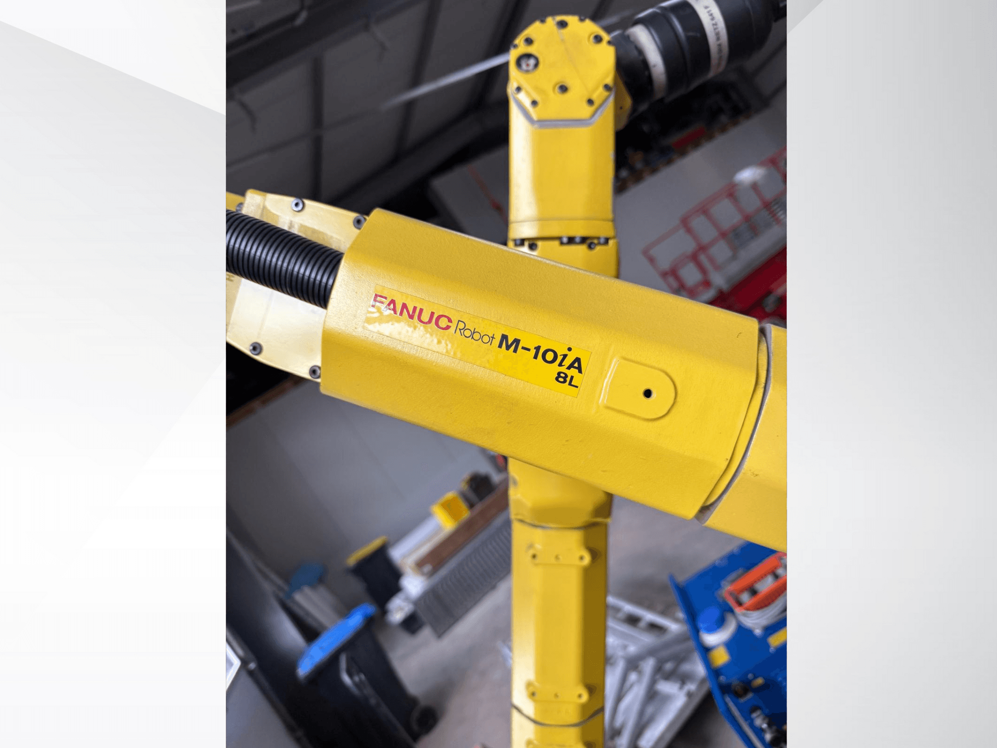 FANUC Robot M-10iA 8L жовтого кольору, вид збоку, демонструє шарнір маніпулятора та механічні компоненти в промислових умовах.