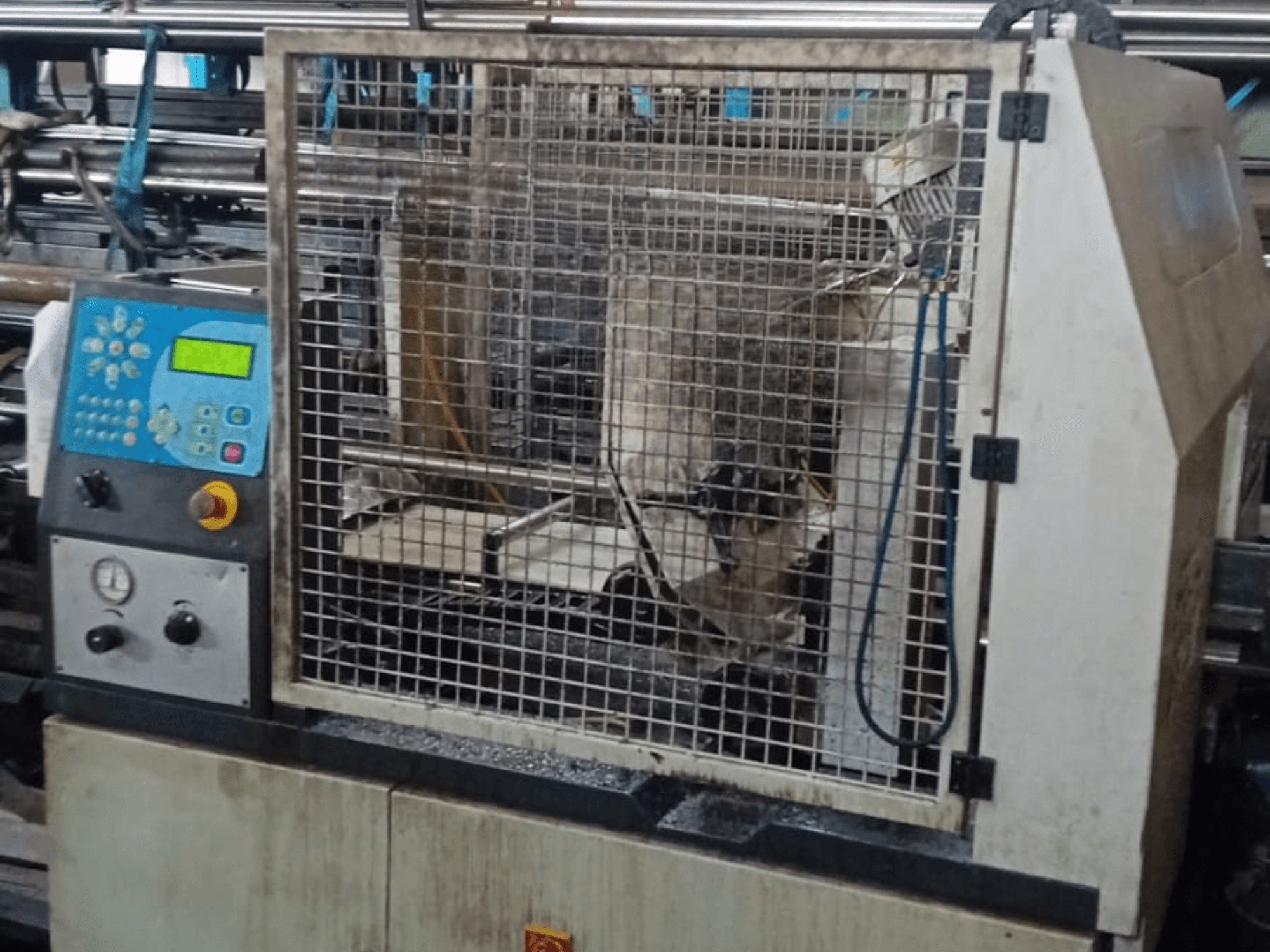 Стрічкова пила по металу Macc 381 AV, вид спереду, з панеллю керування, захисною обоймою та уламками металоконструкцій на основі.