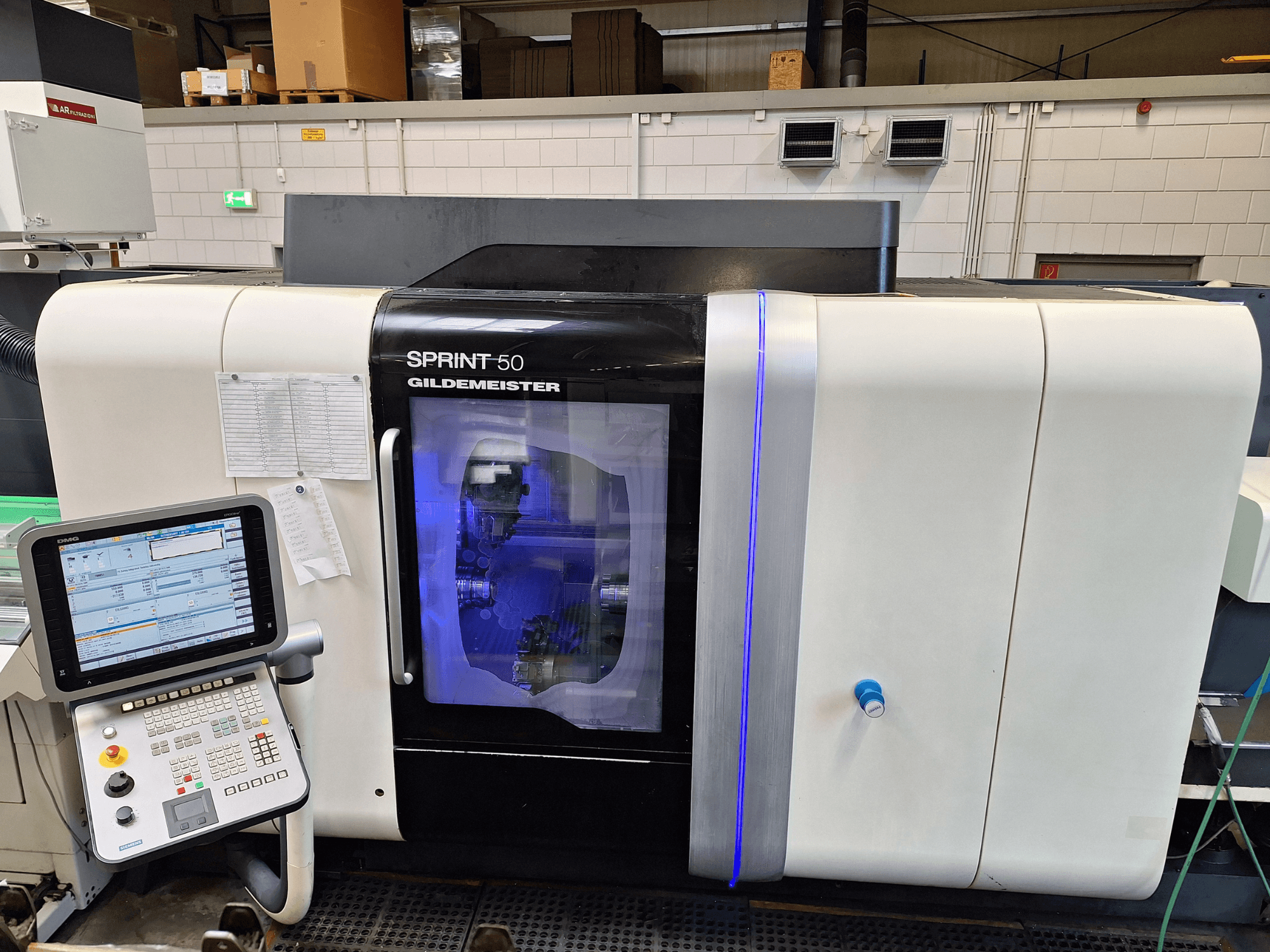 Горизонтальний токарний верстат DMG Sprint 50 2T, вид спереду, з панеллю керування та прозорим кожухом, що демонструє обладнання всередині.