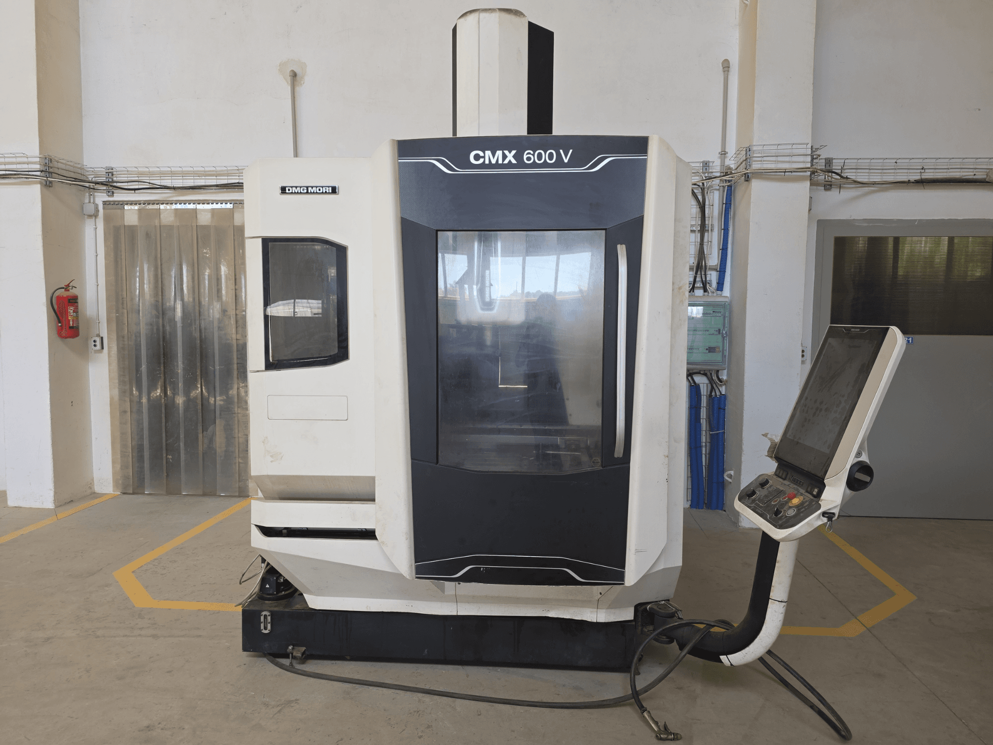Вертикальний обробний центр DMG MORI CMX 600 V, вид спереду, демонстраційна панель керування та велике прозоре вікно.
