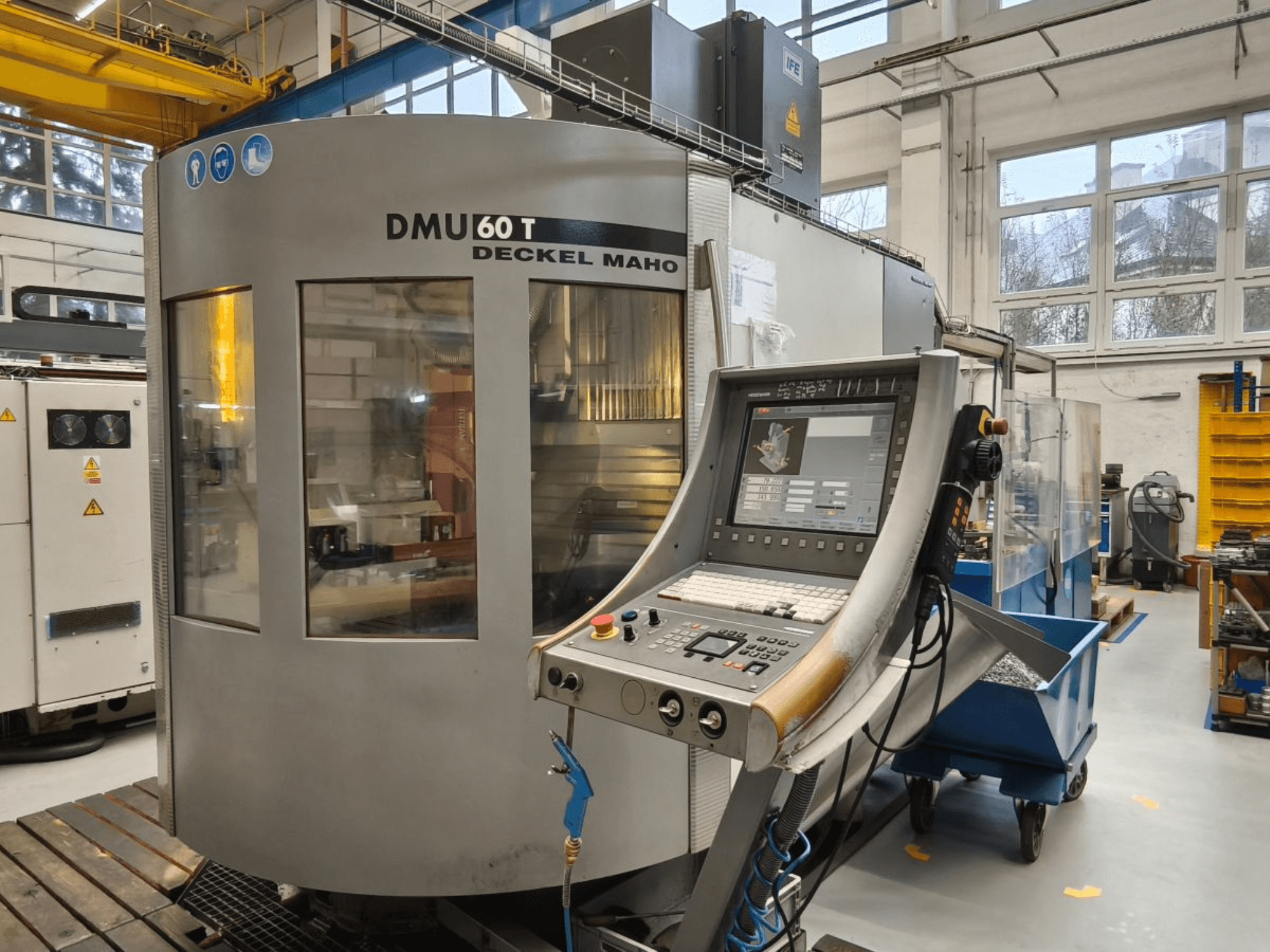 Вертикальний вид обробного центру DECKEL MAHO DMU 60T з панеллю керування, на якій показані прецизійні інструменти в майстерні.