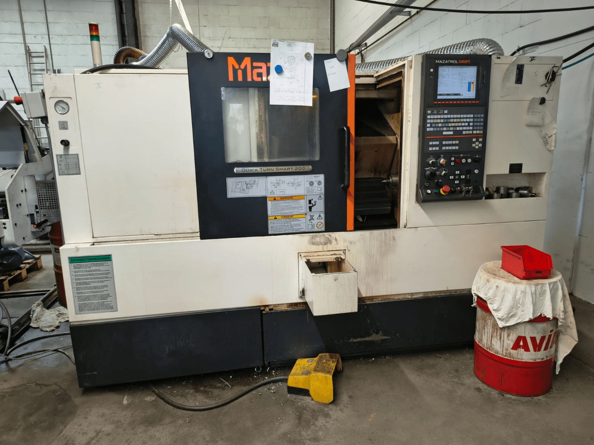 Mazak Quick Turn Smart 200, горизонтальний токарний верстат, вид спереду, на якому видно панель управління, бак для охолоджувальної рідини та маркування.