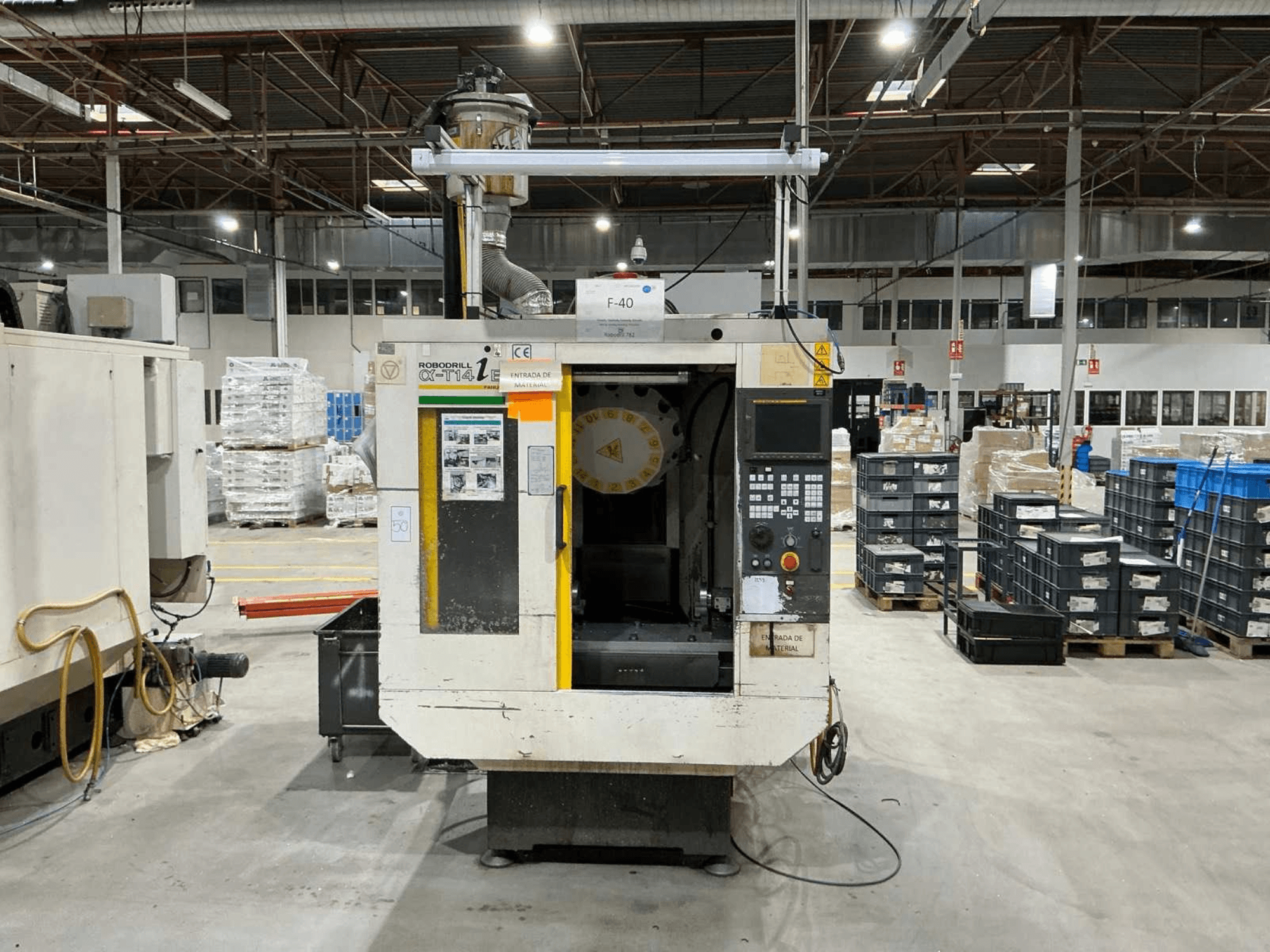 Вертикальний обробний центр FANUC ROBODRILL α-T14iB на заводі, вид спереду з панеллю керування та тримачем інструменту.