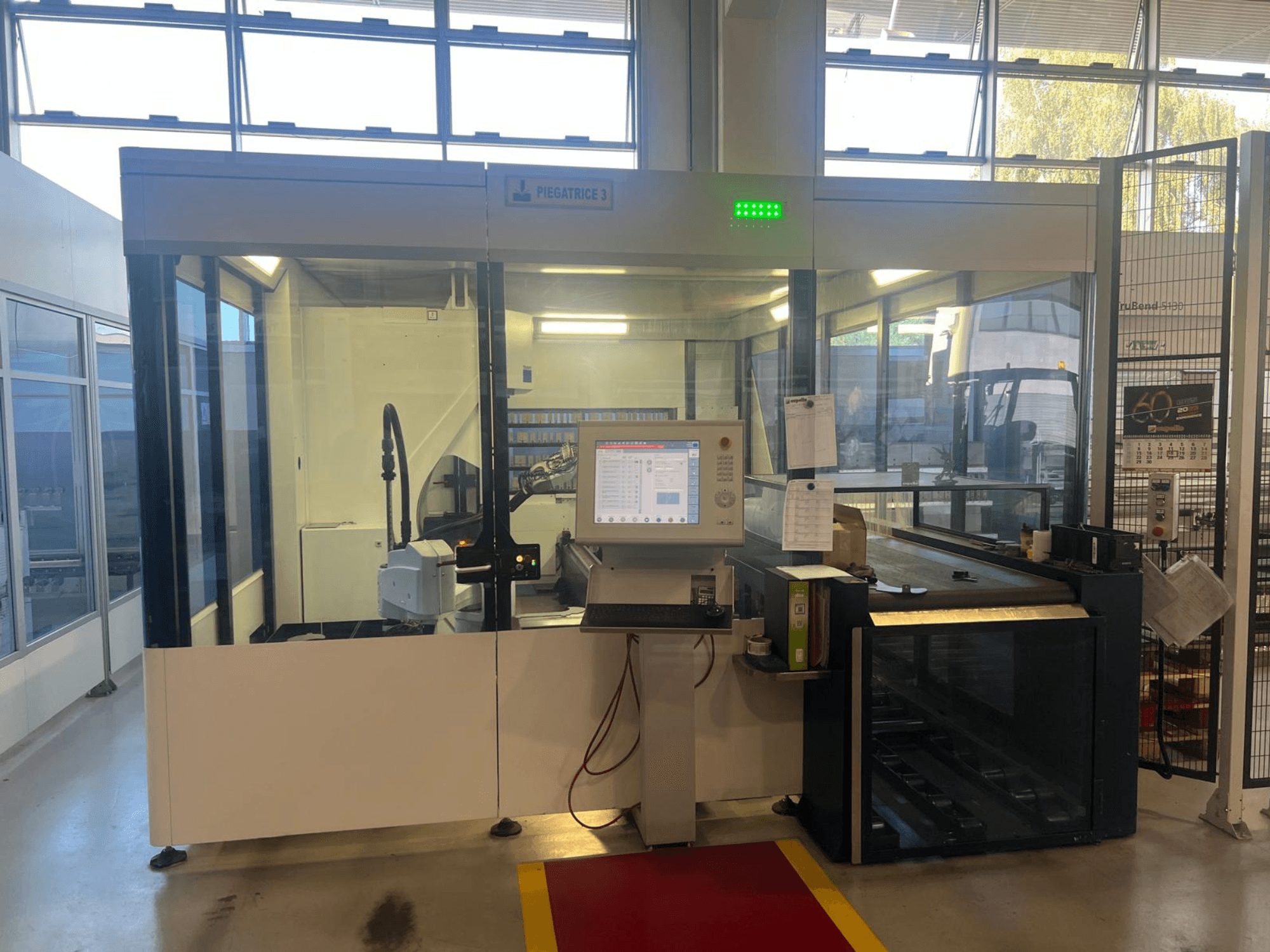 Промисловий згинальний верстат, модель Piegatrice 3, вигляд спереду з панеллю керування та роботизованим маніпулятором, у добре освітленому цеху.