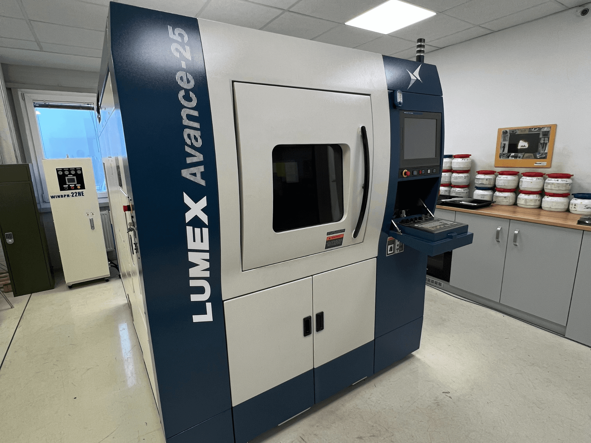 3D-принтер LUMEX Avance-25 в лабораторних умовах, вигляд спереду. Видно панель керування з екраном і кнопками, обладнання на задньому плані.