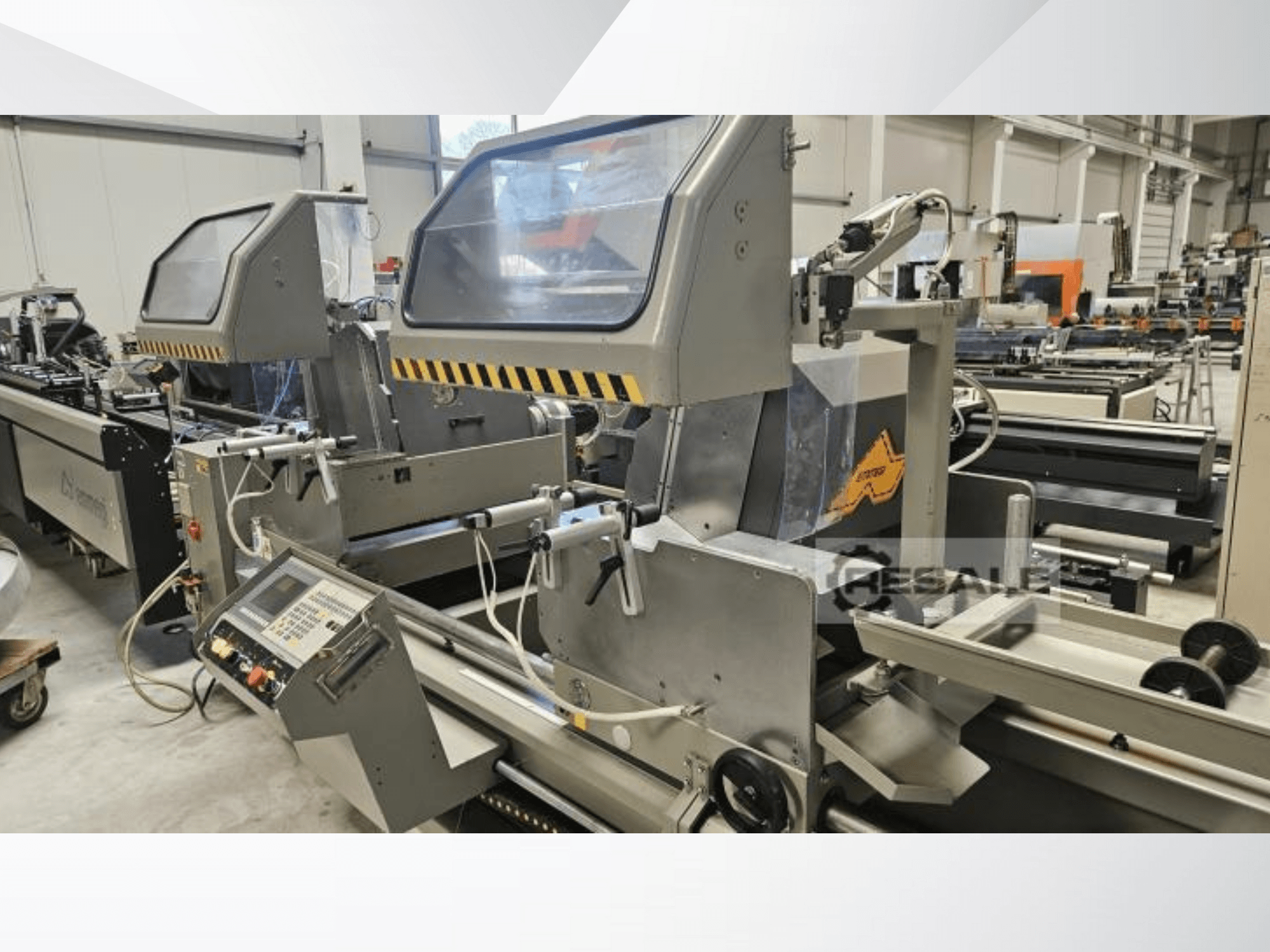 Двопилкові верстати в заводських умовах; вид спереду: панель керування, скляні кришки та ріжучі компоненти.