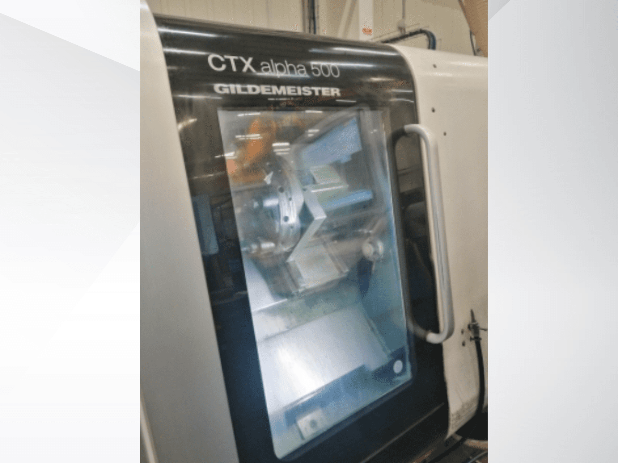 Верстат з ЧПК CTX alpha 500 Gildemeister, вид спереду, через скляні дверцята видно шпиндель і зону обробки.